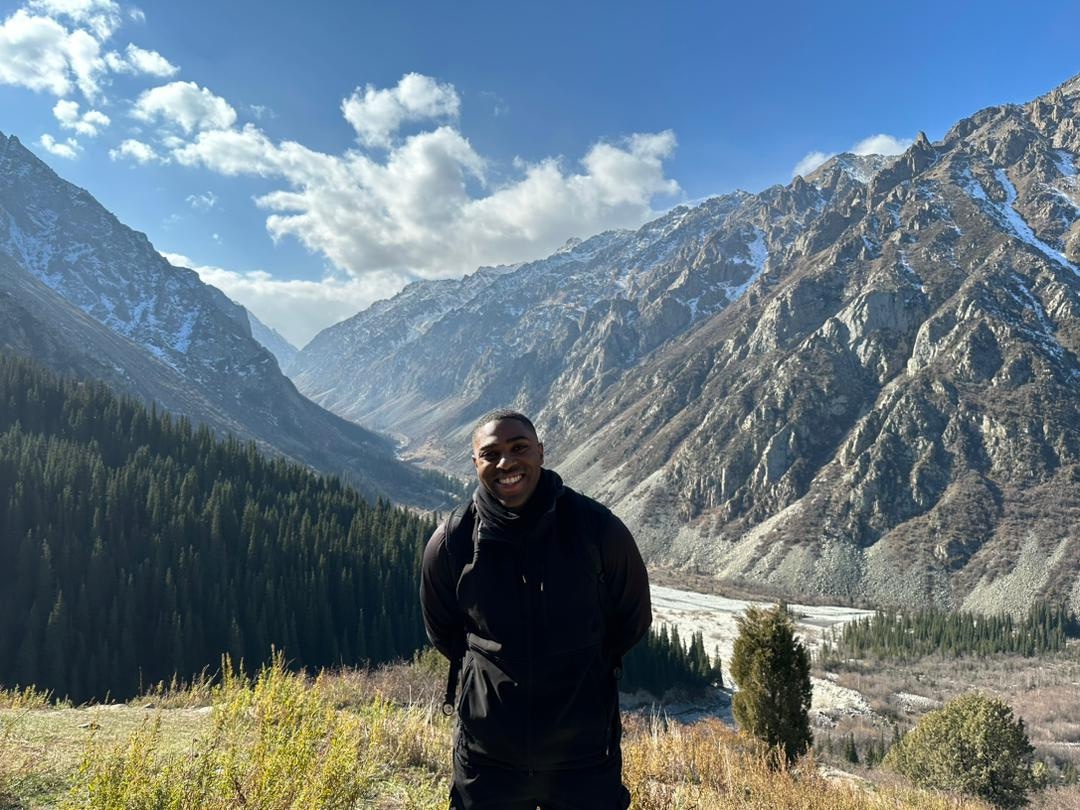 Denzell Ivery posing for photo in front of a scenic valley