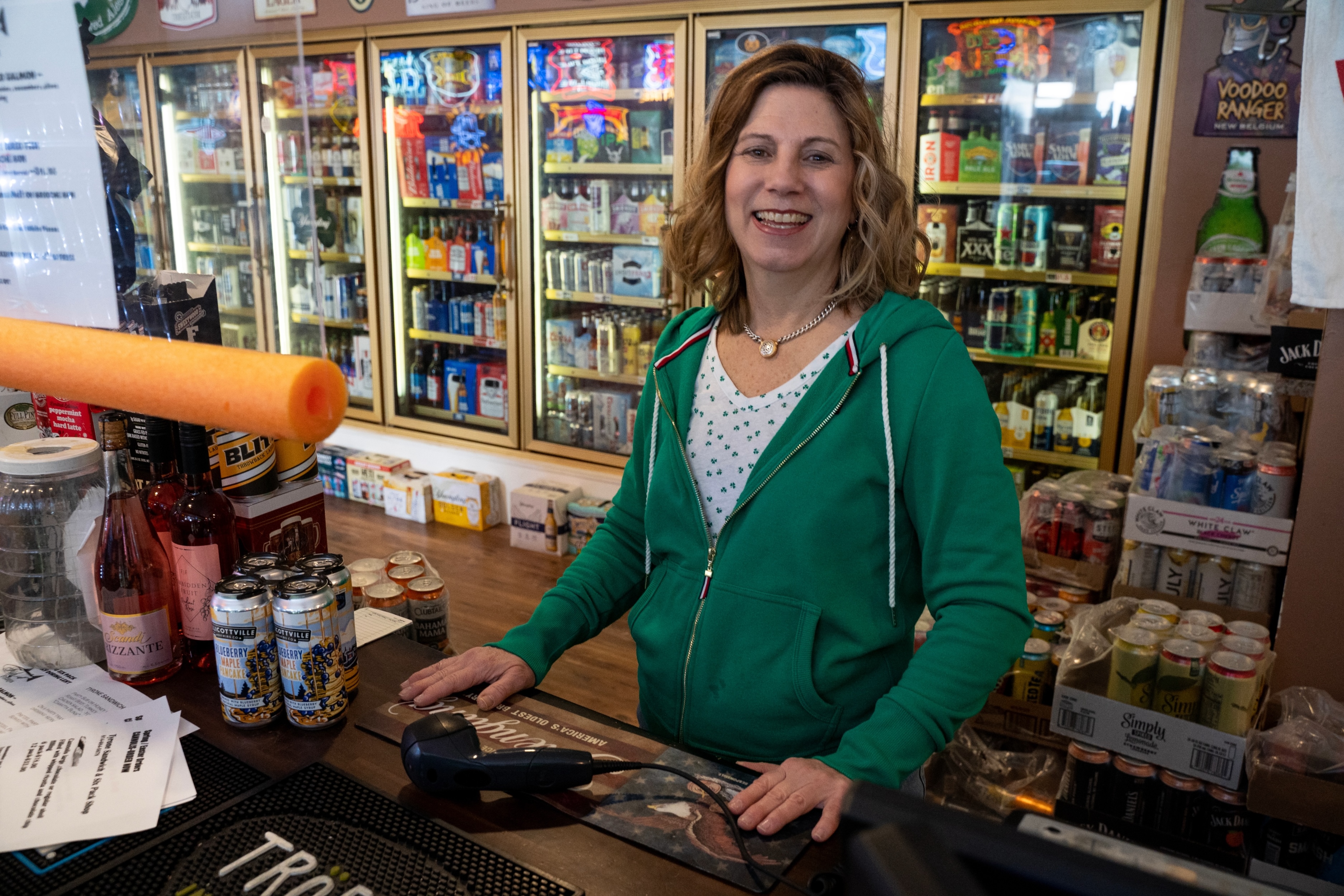 Woman standing at sales counter in store.