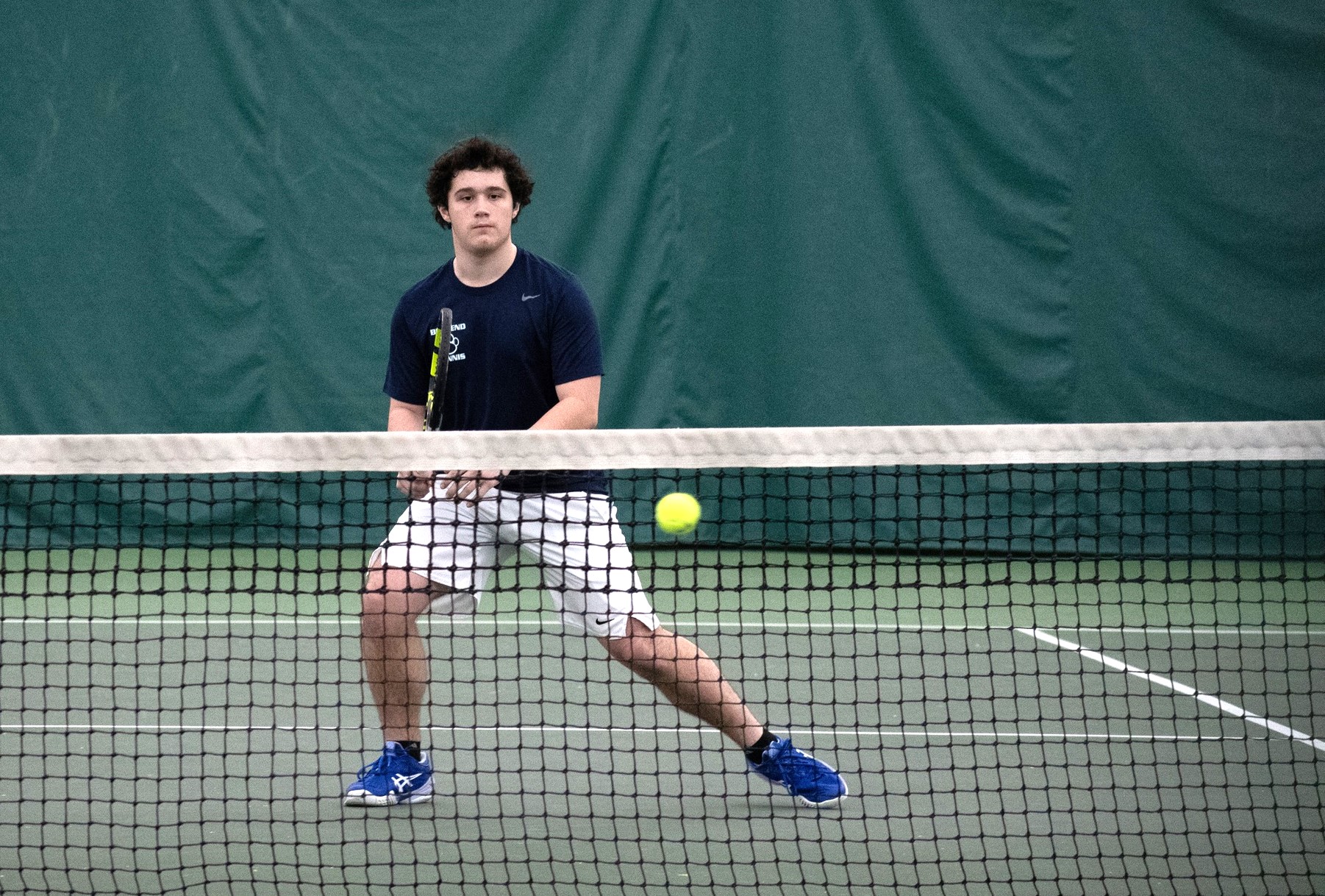 A member of the Penn State Behrend men's tennis team prepares to hit a ball.