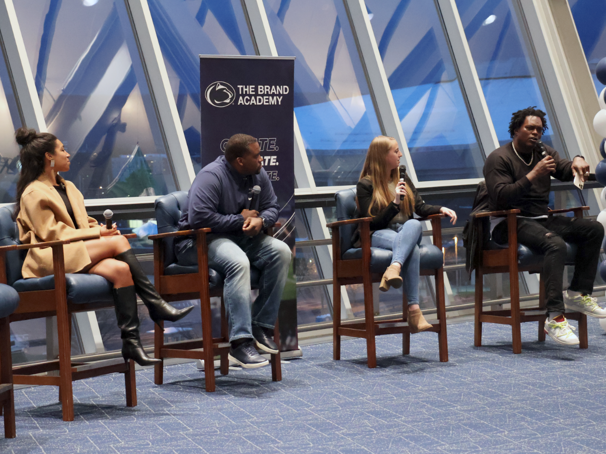 Four former student-athletes sit in front of room as a panel