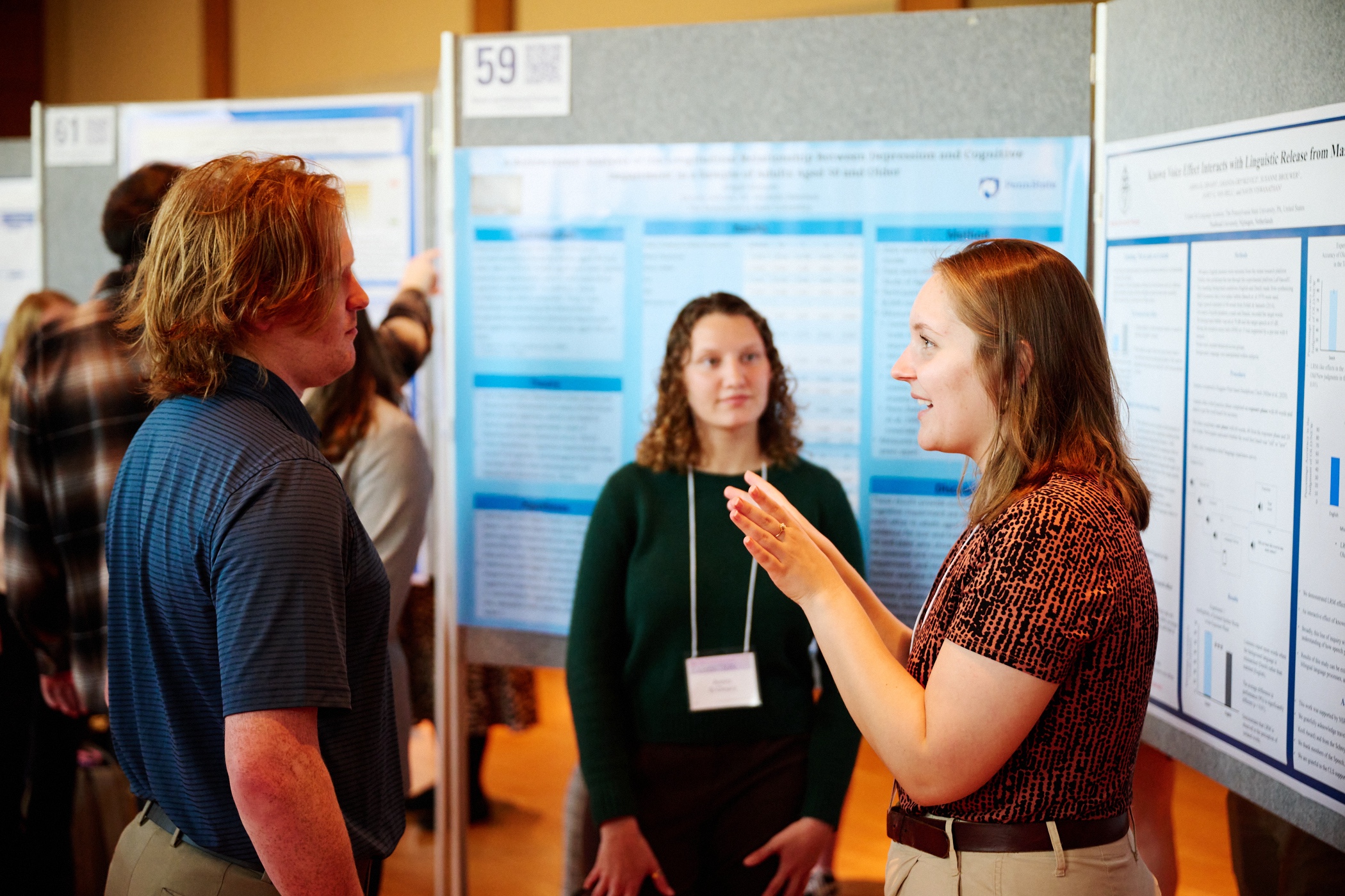 Student exhibition presenter talking in front of research poster