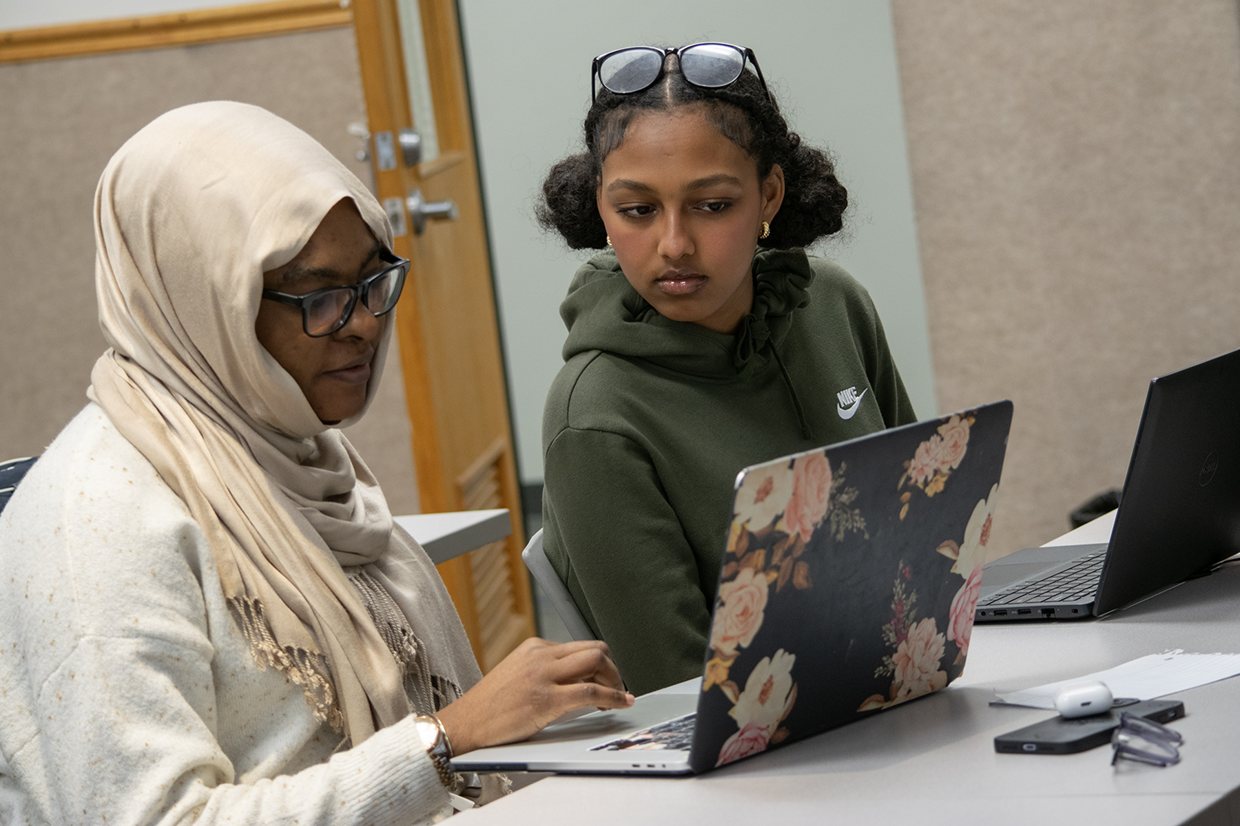 Two people in front of laptops. 