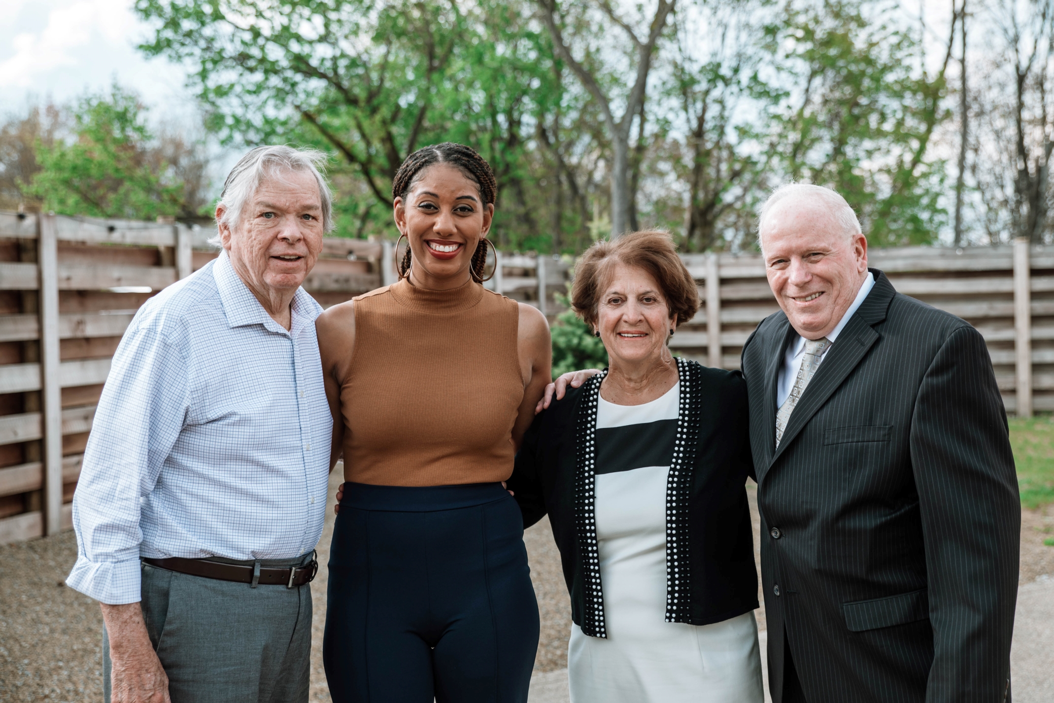 Four individuals stand smiling and posing for photo