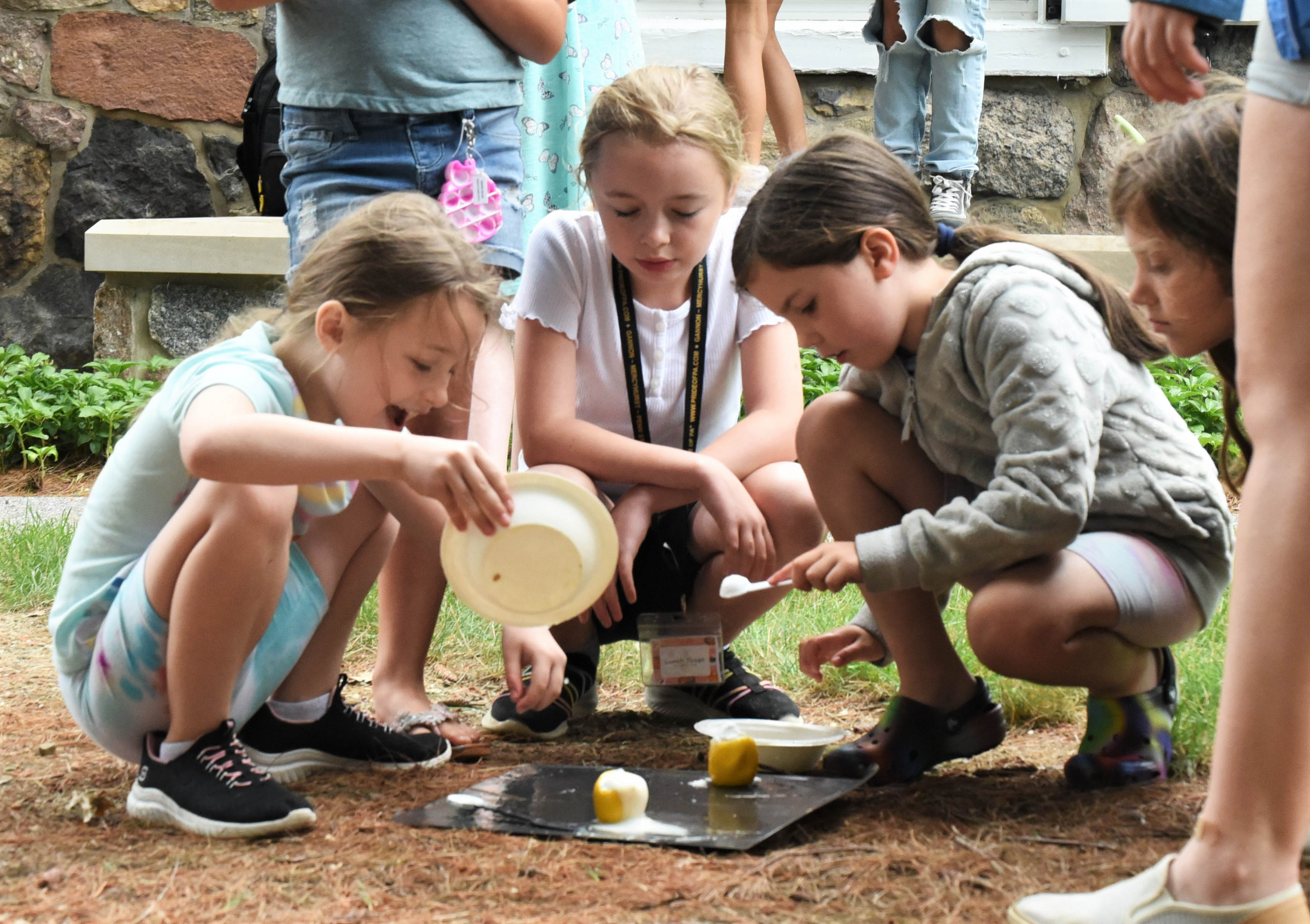 Three children conduct an outdoor science project during Penn State Behrend's College for Kids program.