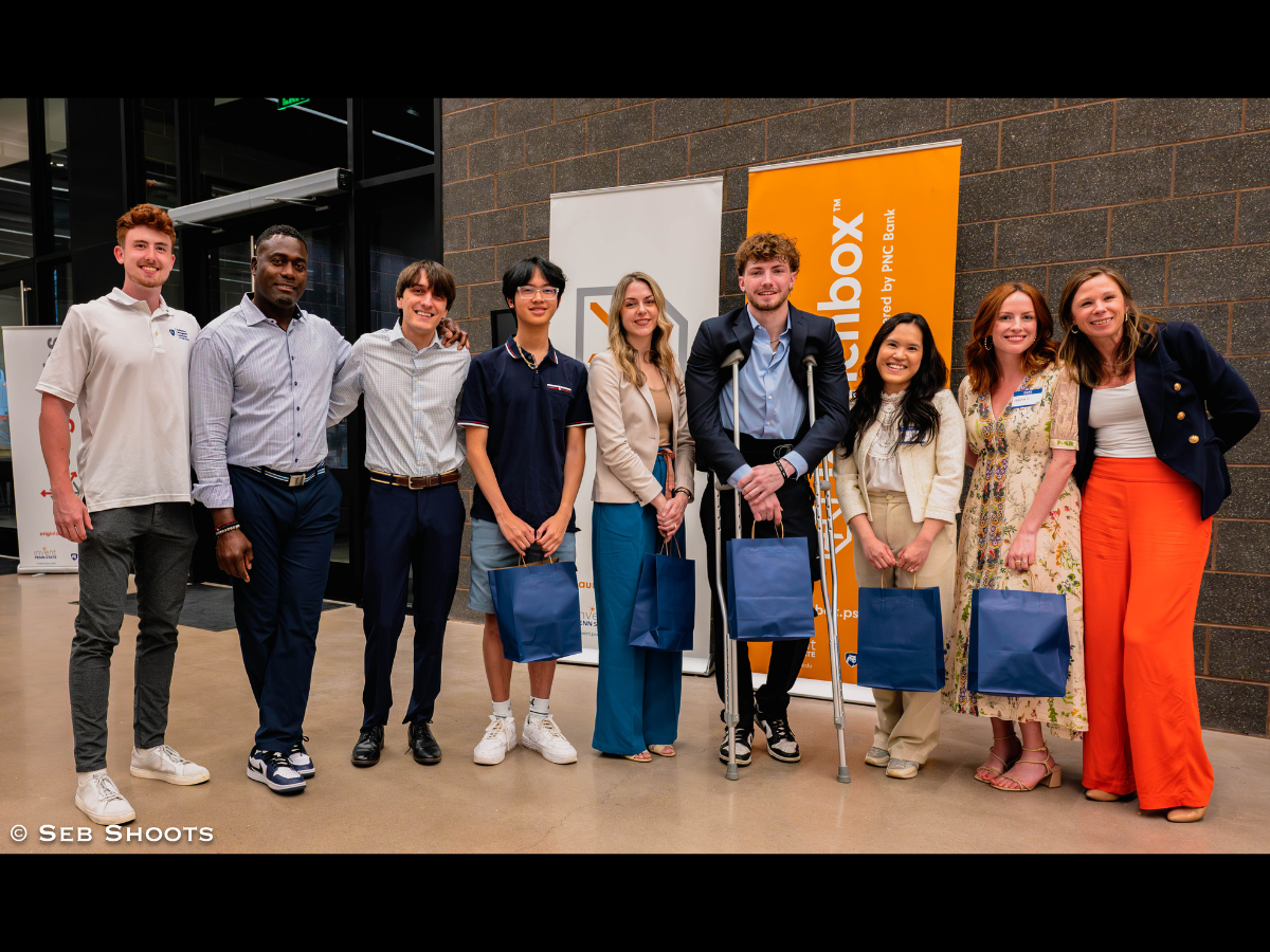 Nine individuals pose for photo together in front of Happy Valley LaunchBox powered by PNC Bank signage