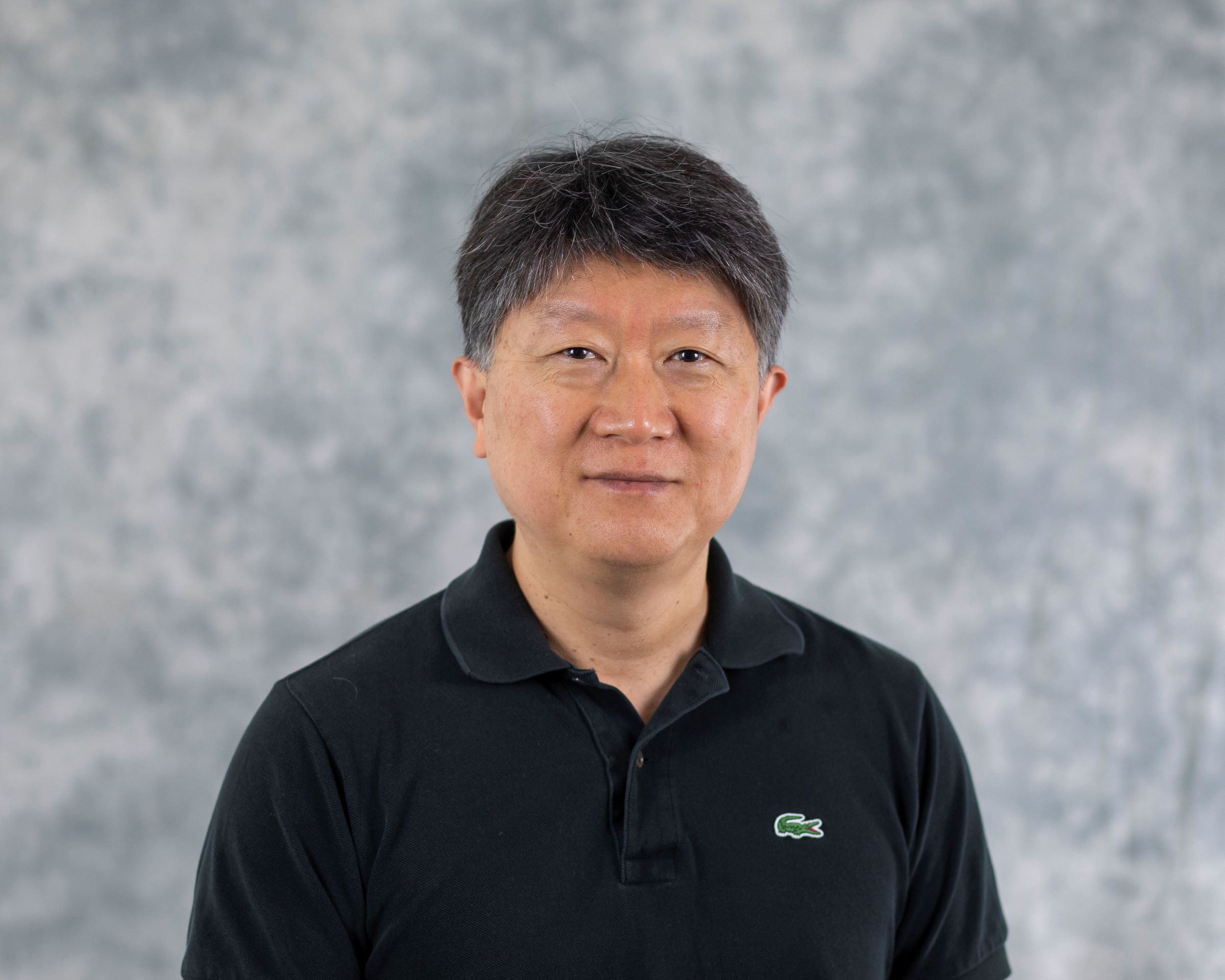 headshot of dark-haired person in black golf shirt