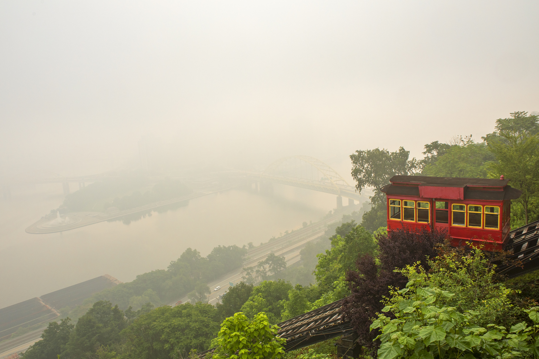 The Duquesne Incline descending a mountain, with Pittsburgh in the background obscured by wildfire smoke