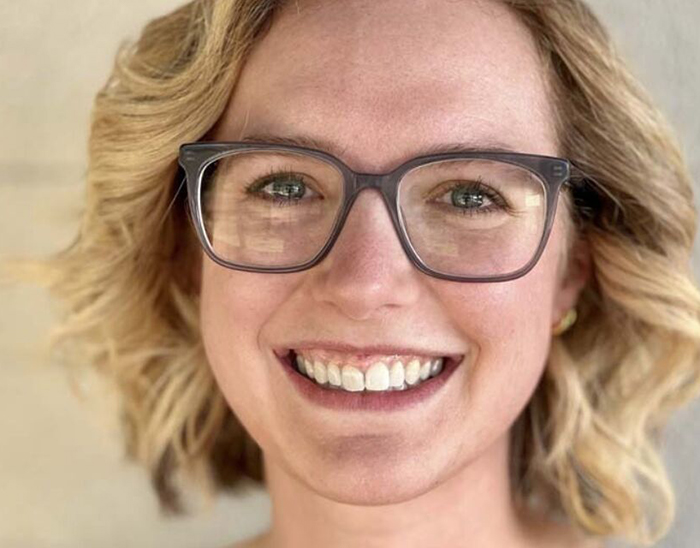 Smiling blond-haired women wearing glasses