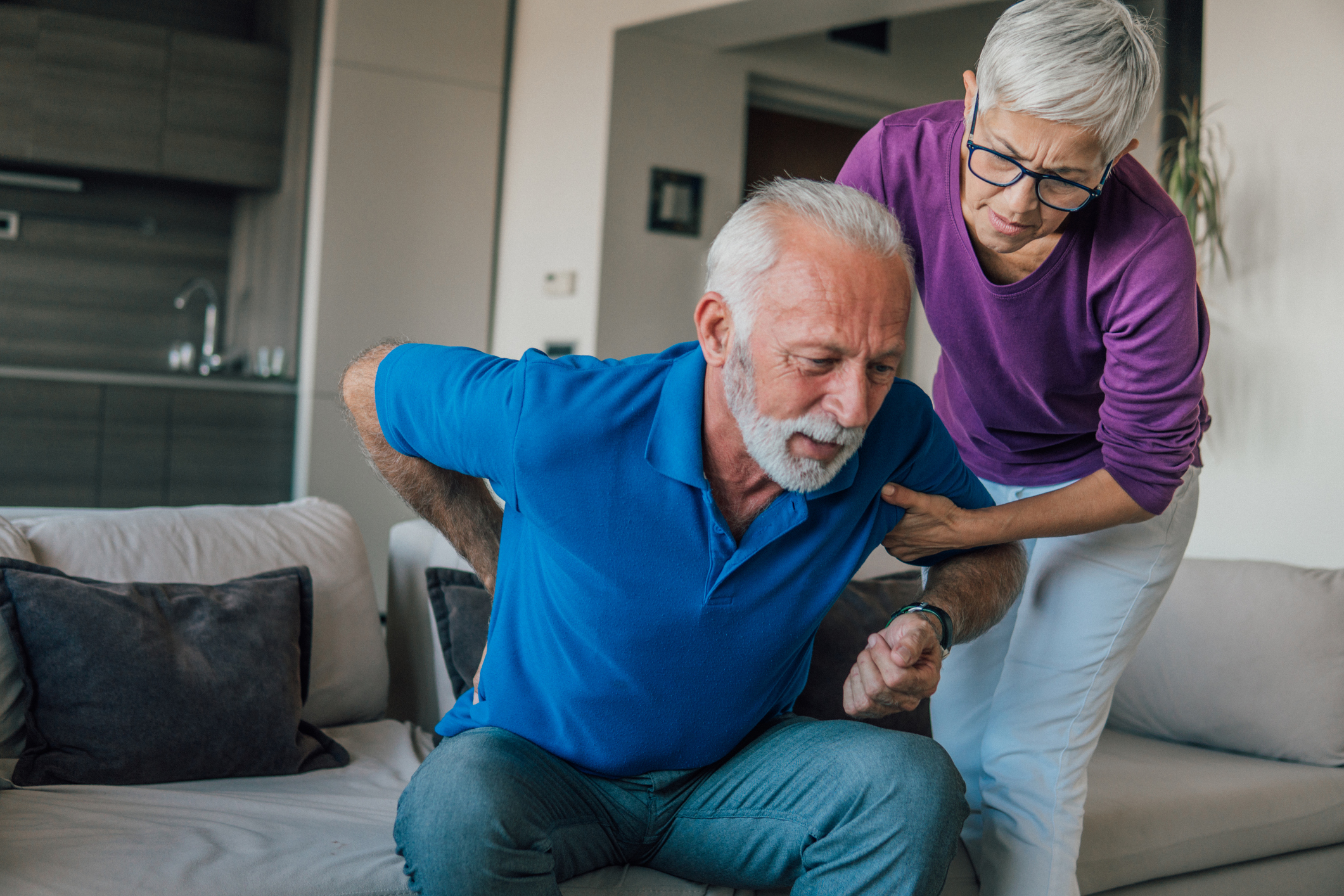 an older person helps another person change position