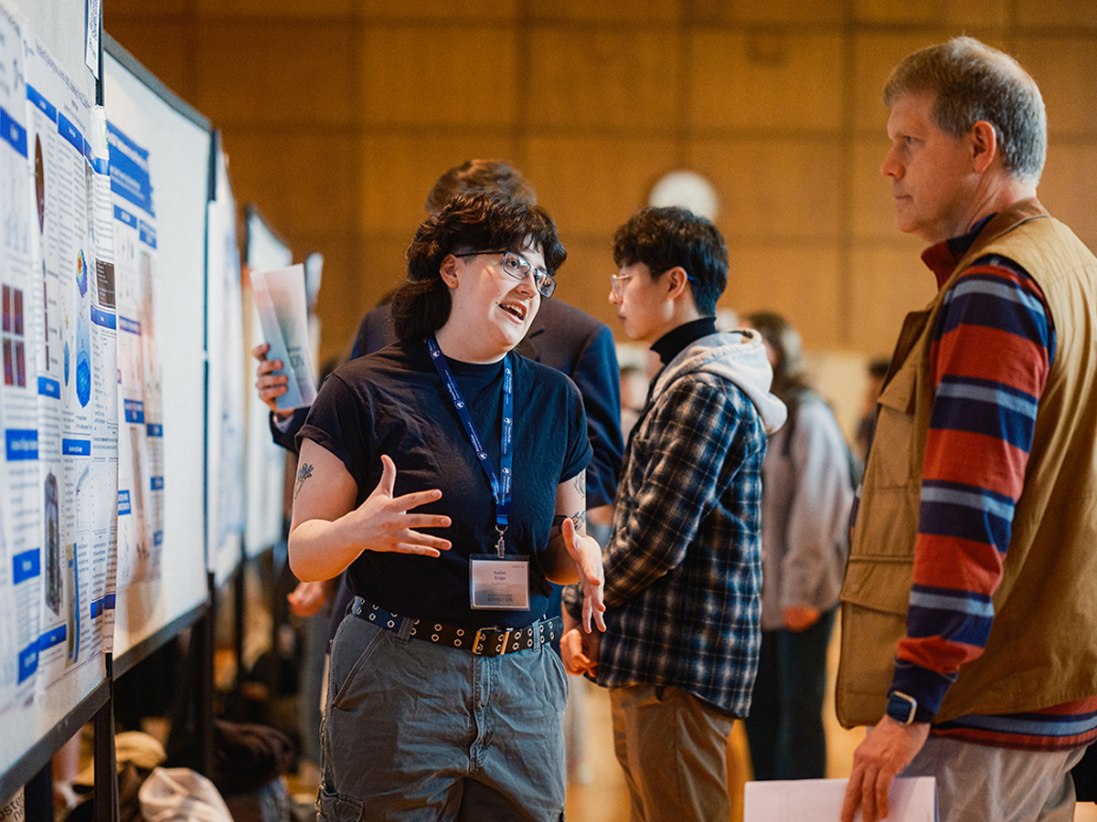 A student presents their project to faculty member at 2024 Undergraduate Exhibition.