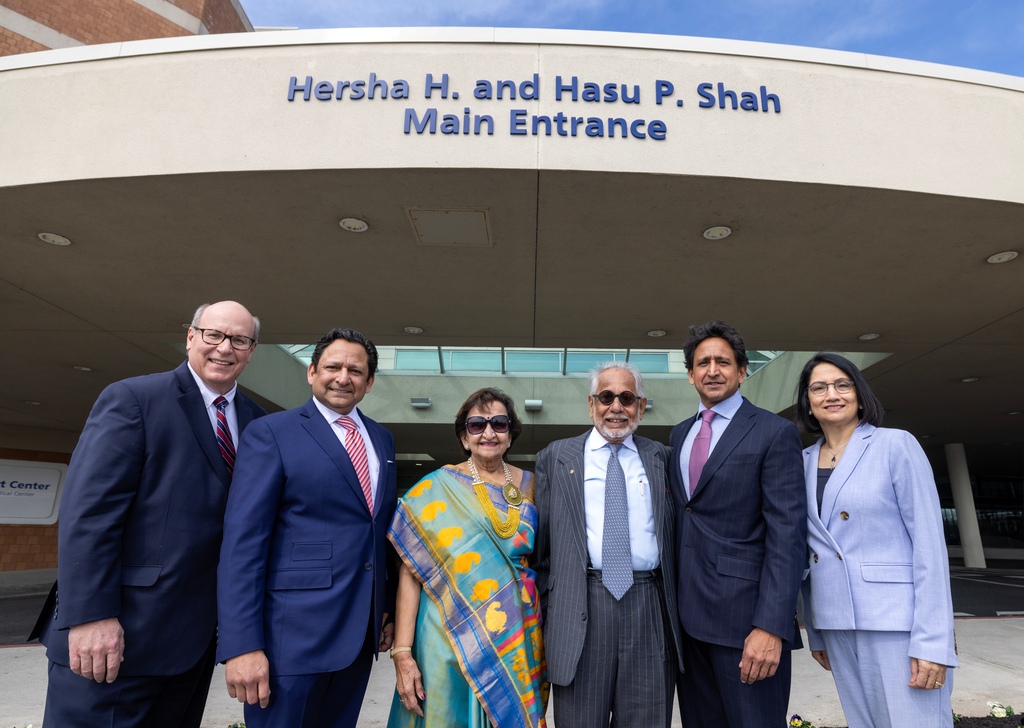 Six people in professional attire pose for a photo in front of Penn State Health Holy Spirit Medical Center.