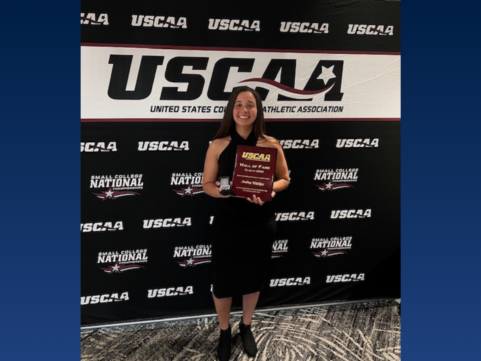 A college student holding an award