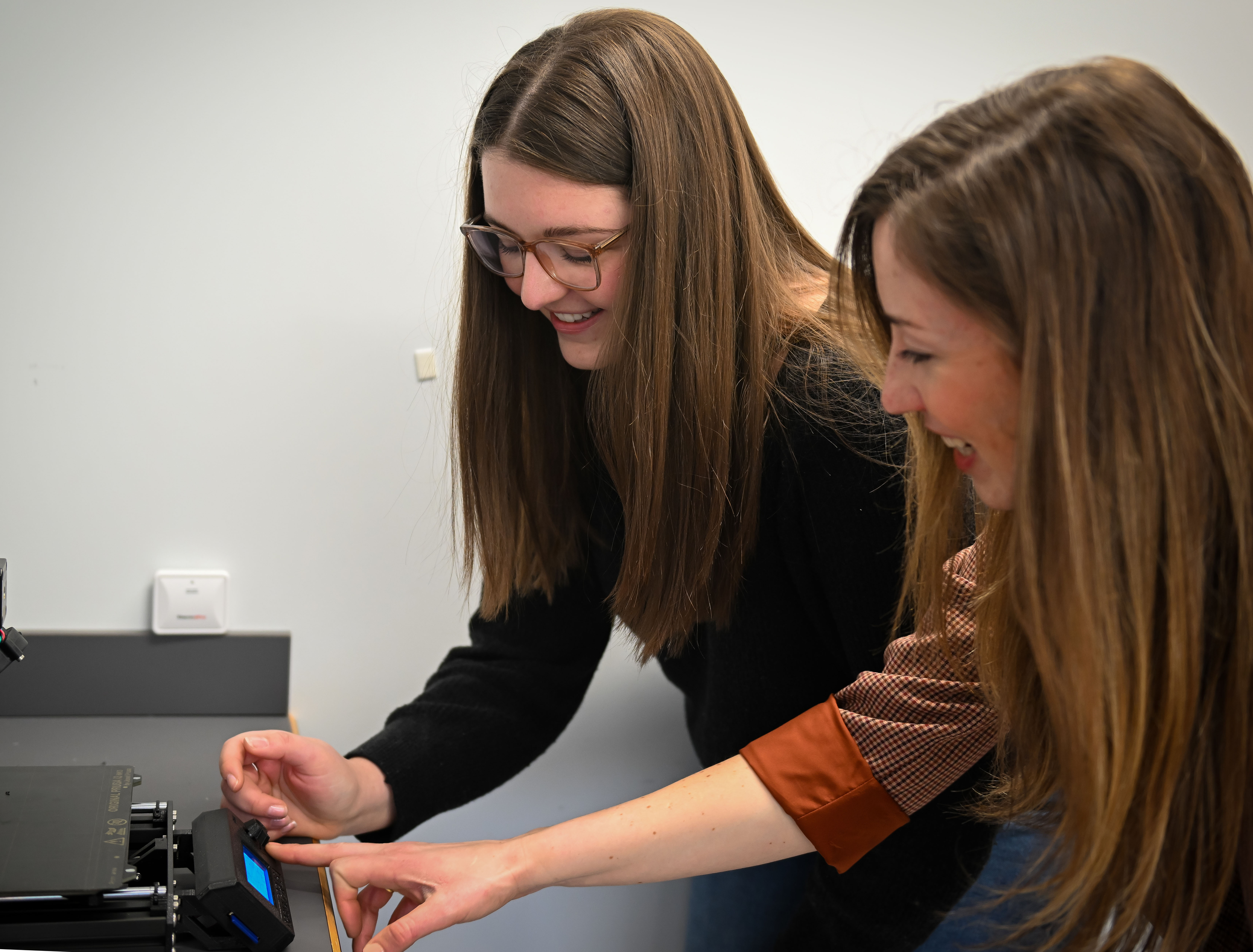 Jessica Menold, Center for Immersive Experiences director, at right, helps a graduate student on a 3-D print project.