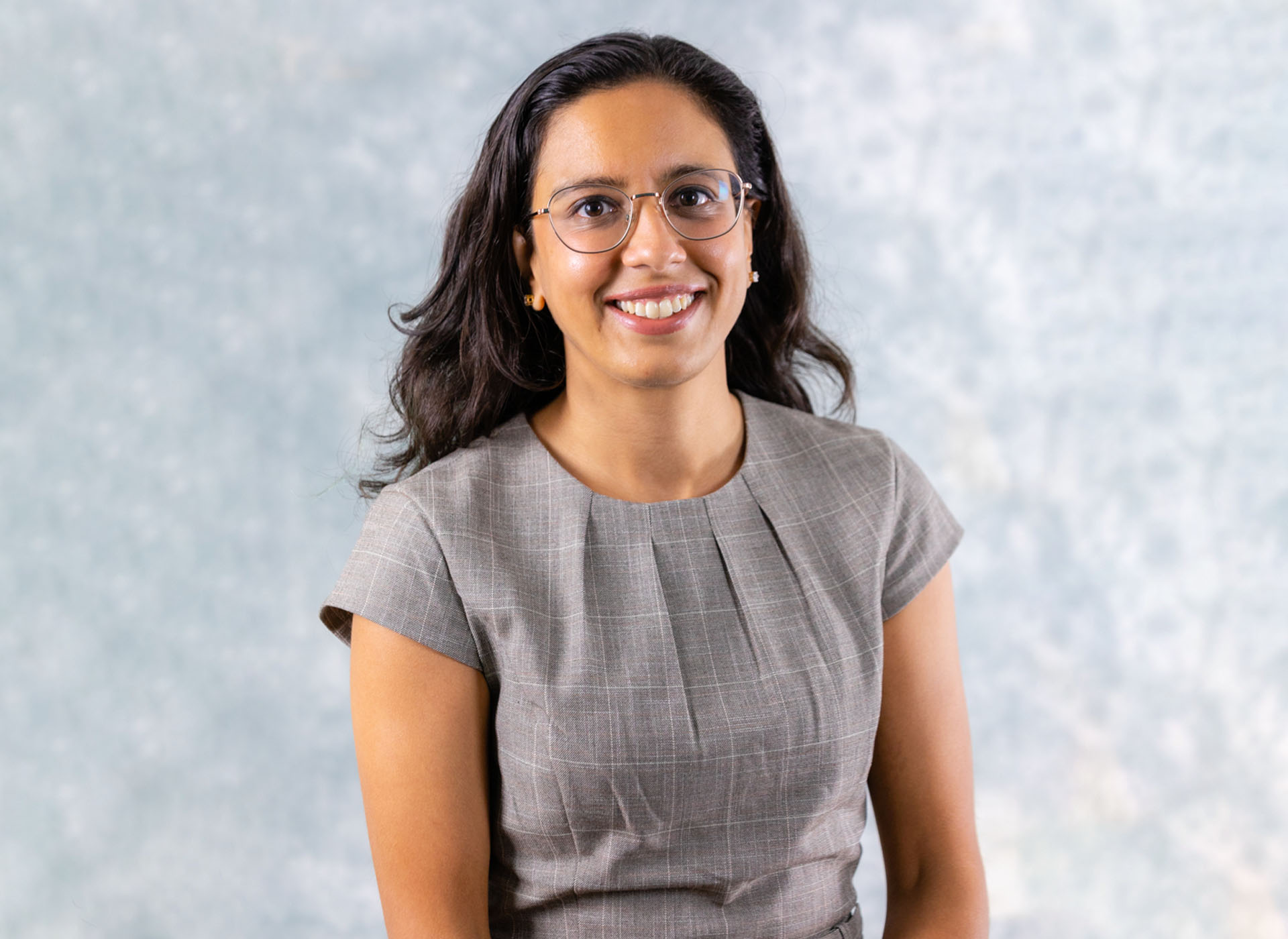 person with long dark hair and glasses