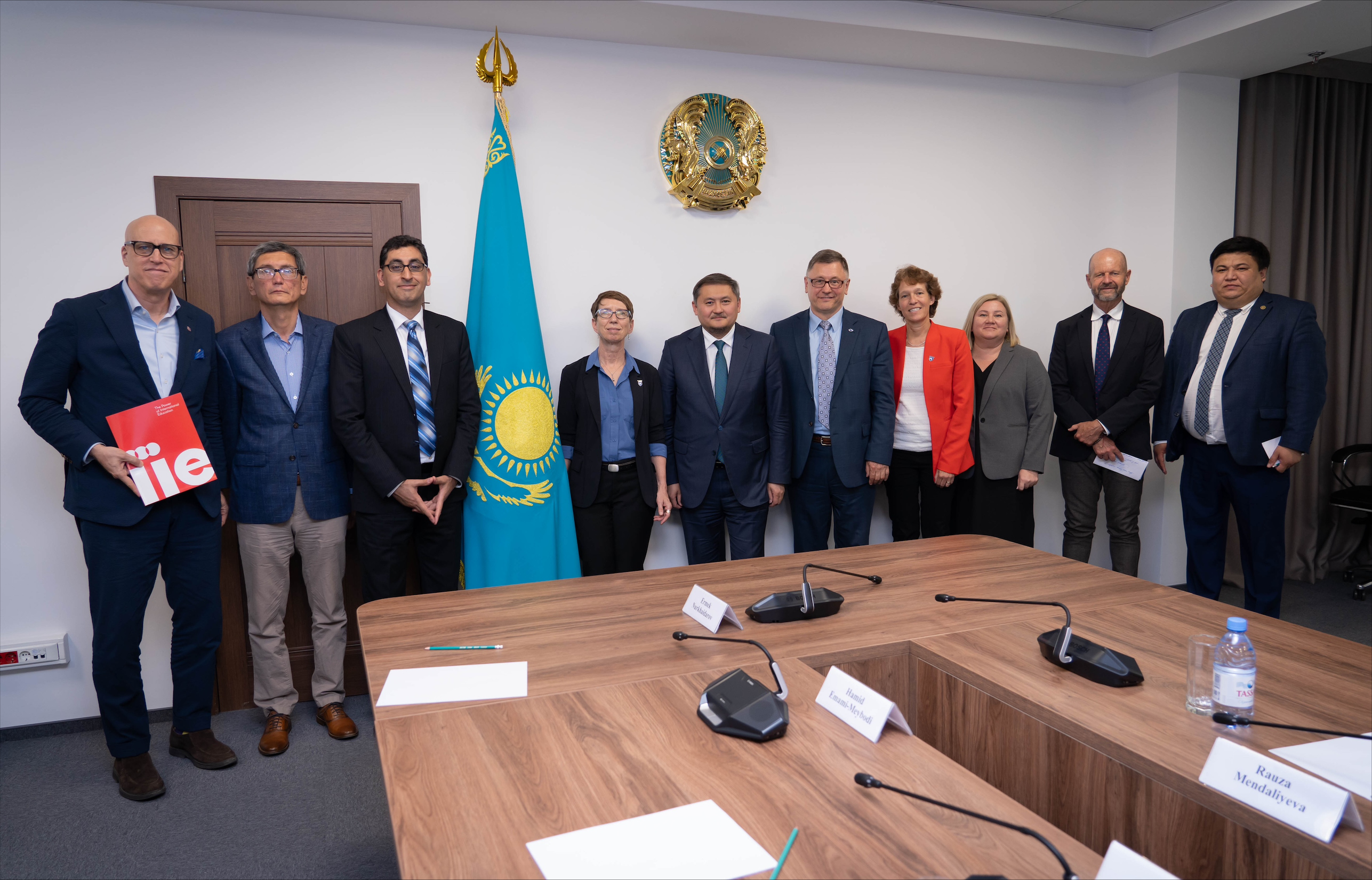 A group of people standing in a semicircle around a table