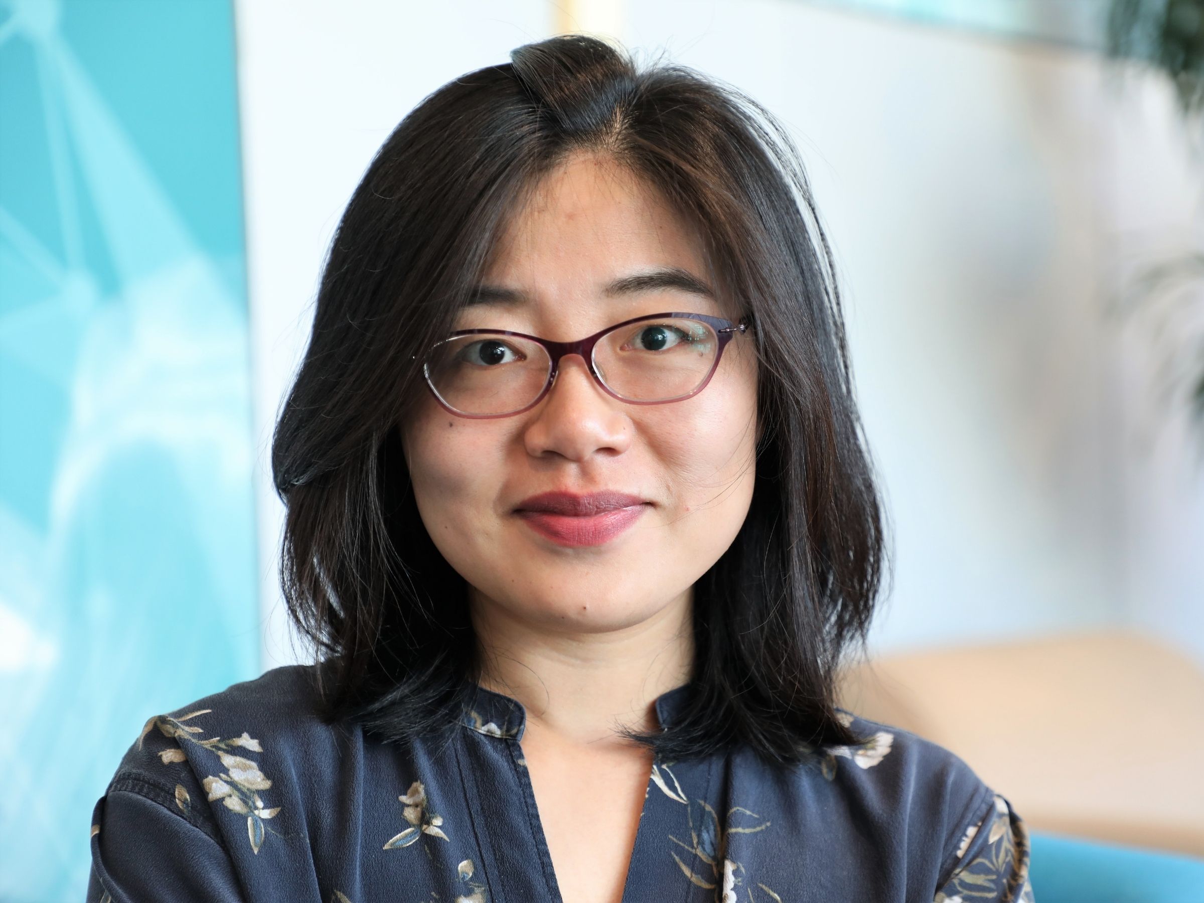 headshot of person with glasses and shoulder length dark hair