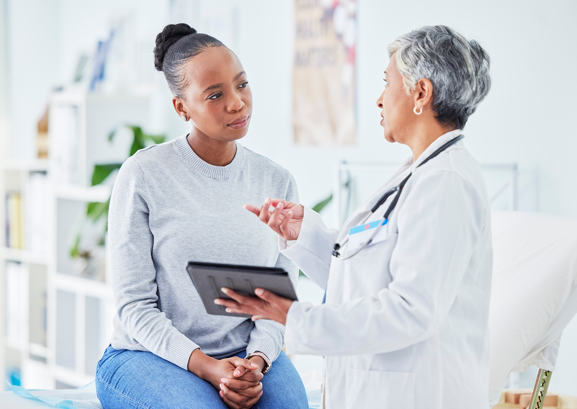 Doctor holding tablet speaking with a patient