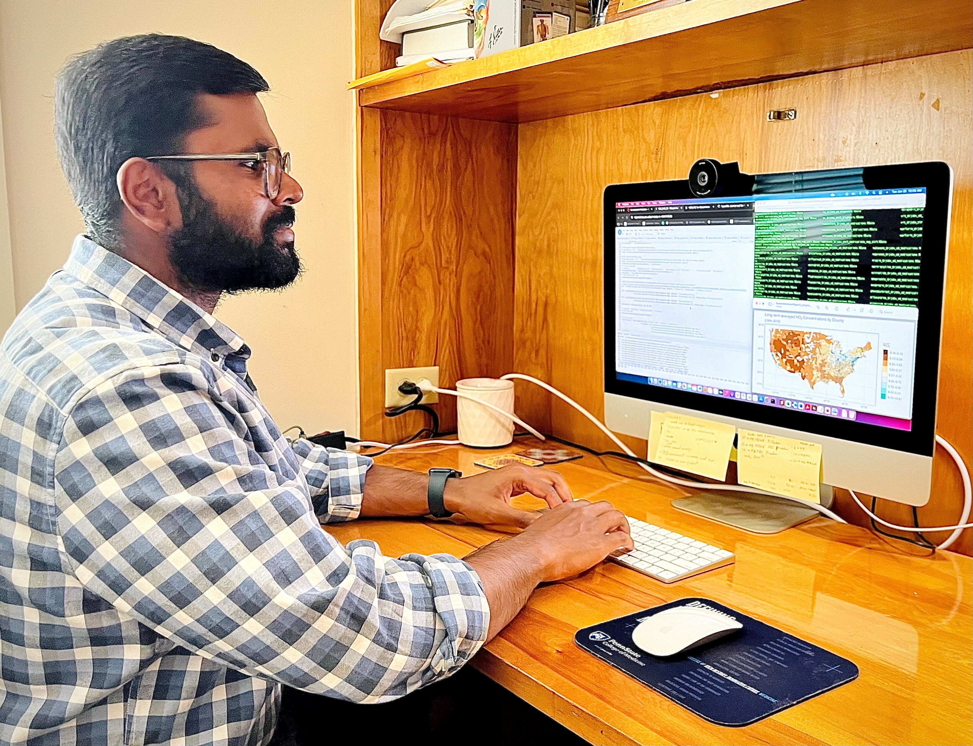 Research scientist sitting at a desk and looking at data sets on a computer