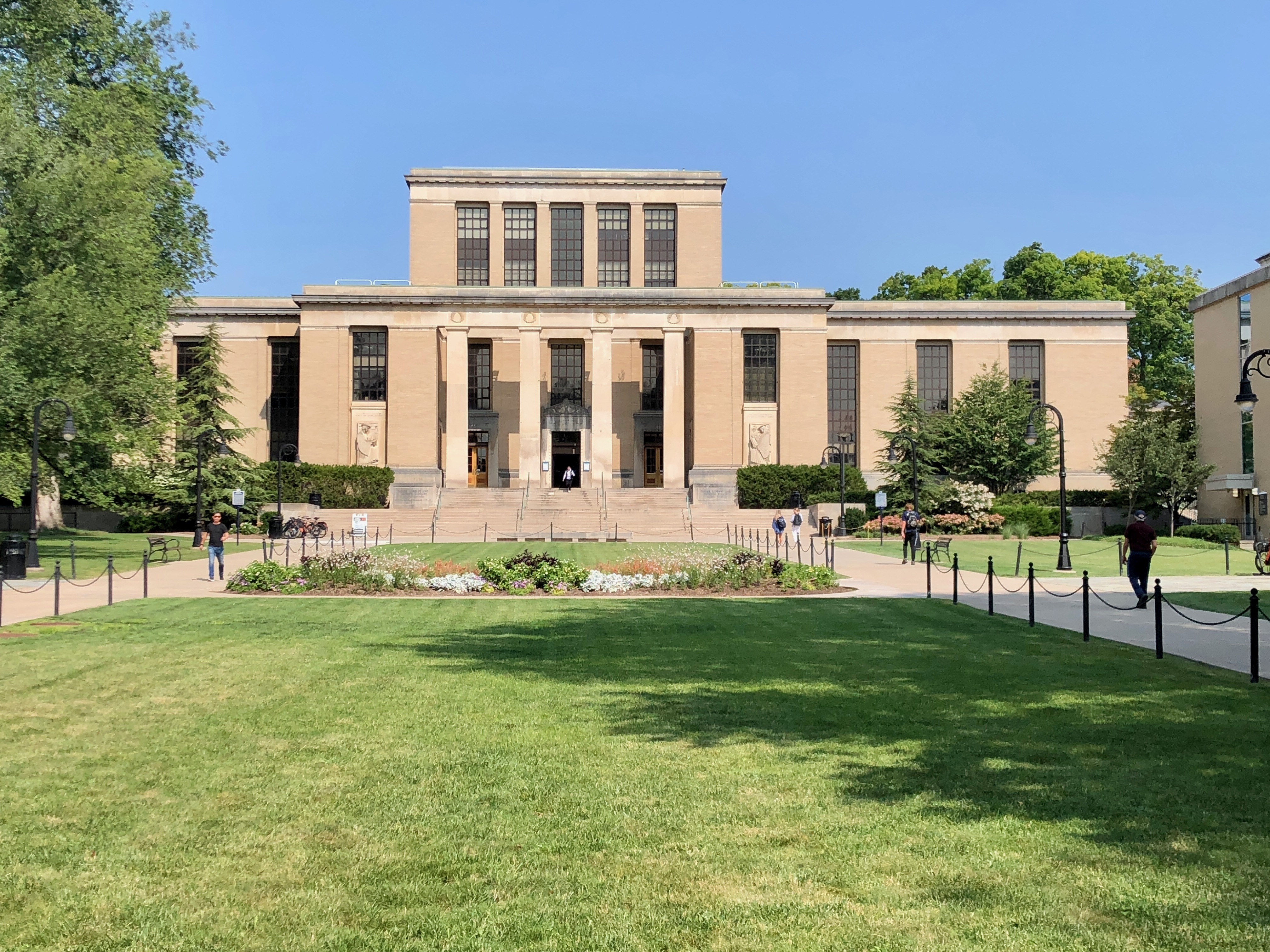 summer exterior view of large university library building and lawn