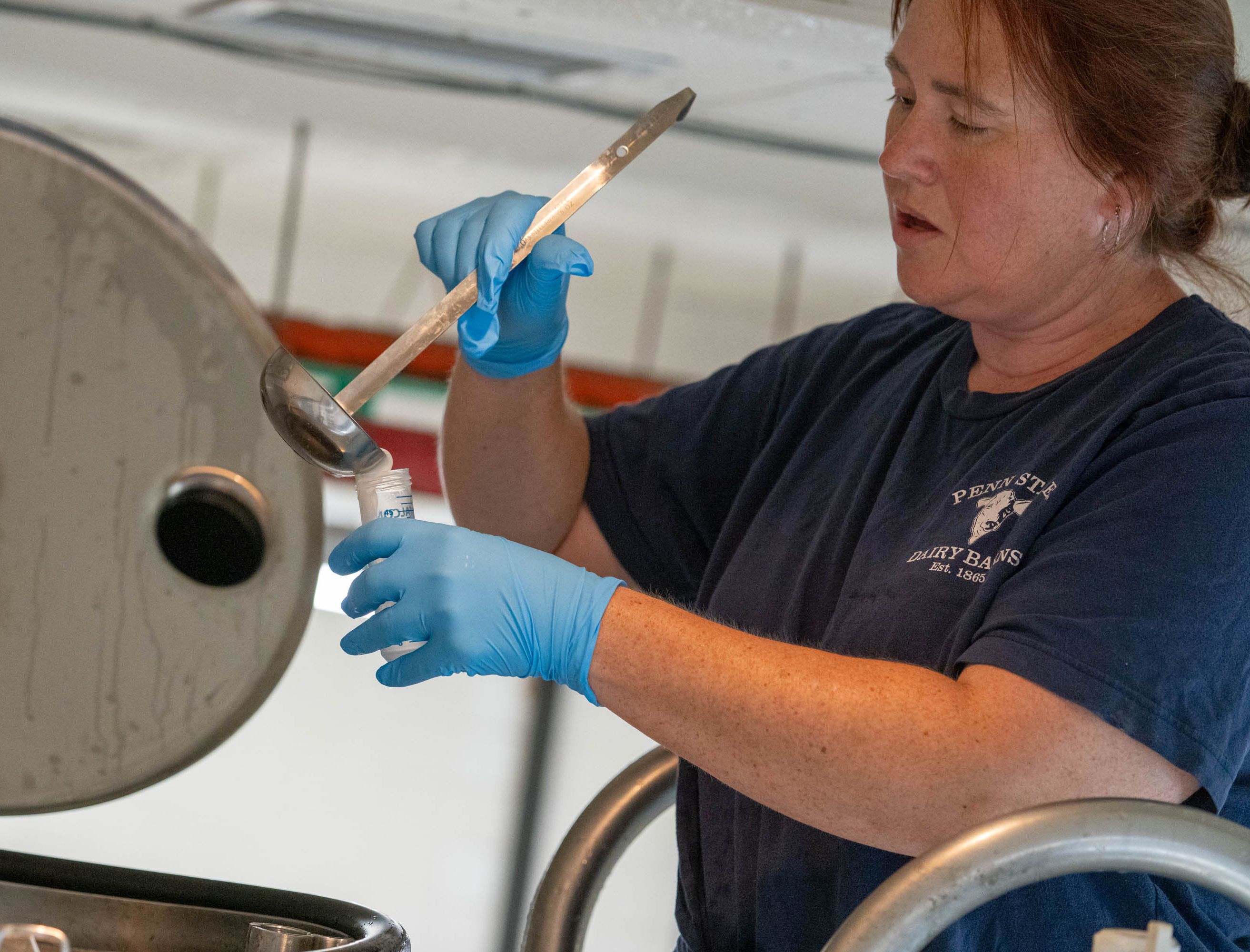 Person ladles milk sample into a tube