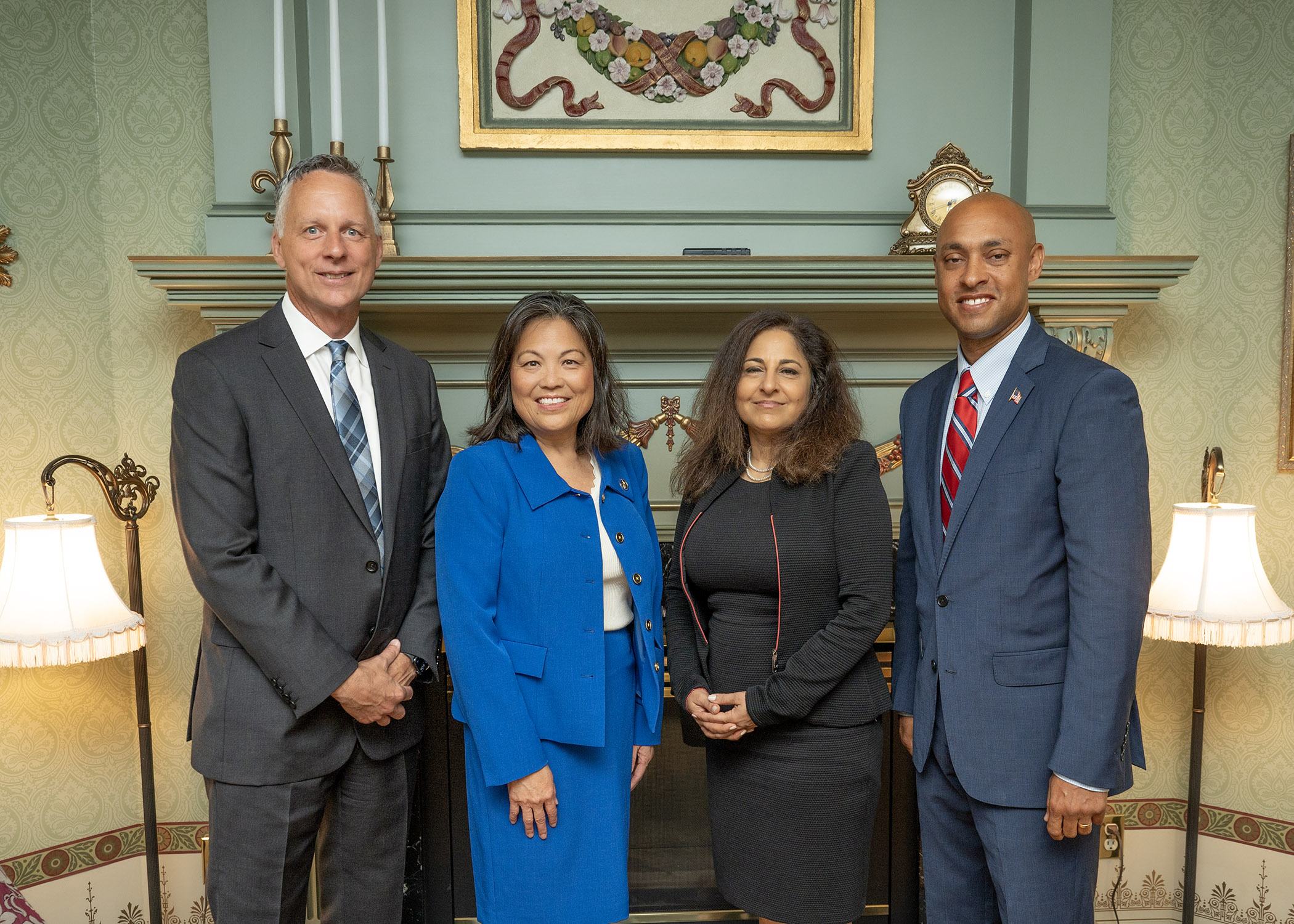 Four people pose for a photo in a parlor