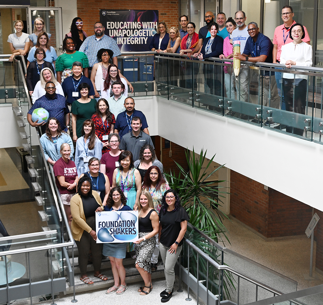 The first cohort of World Campus D.Ed. students pose on the stairs in the atrium of Chambers Building.