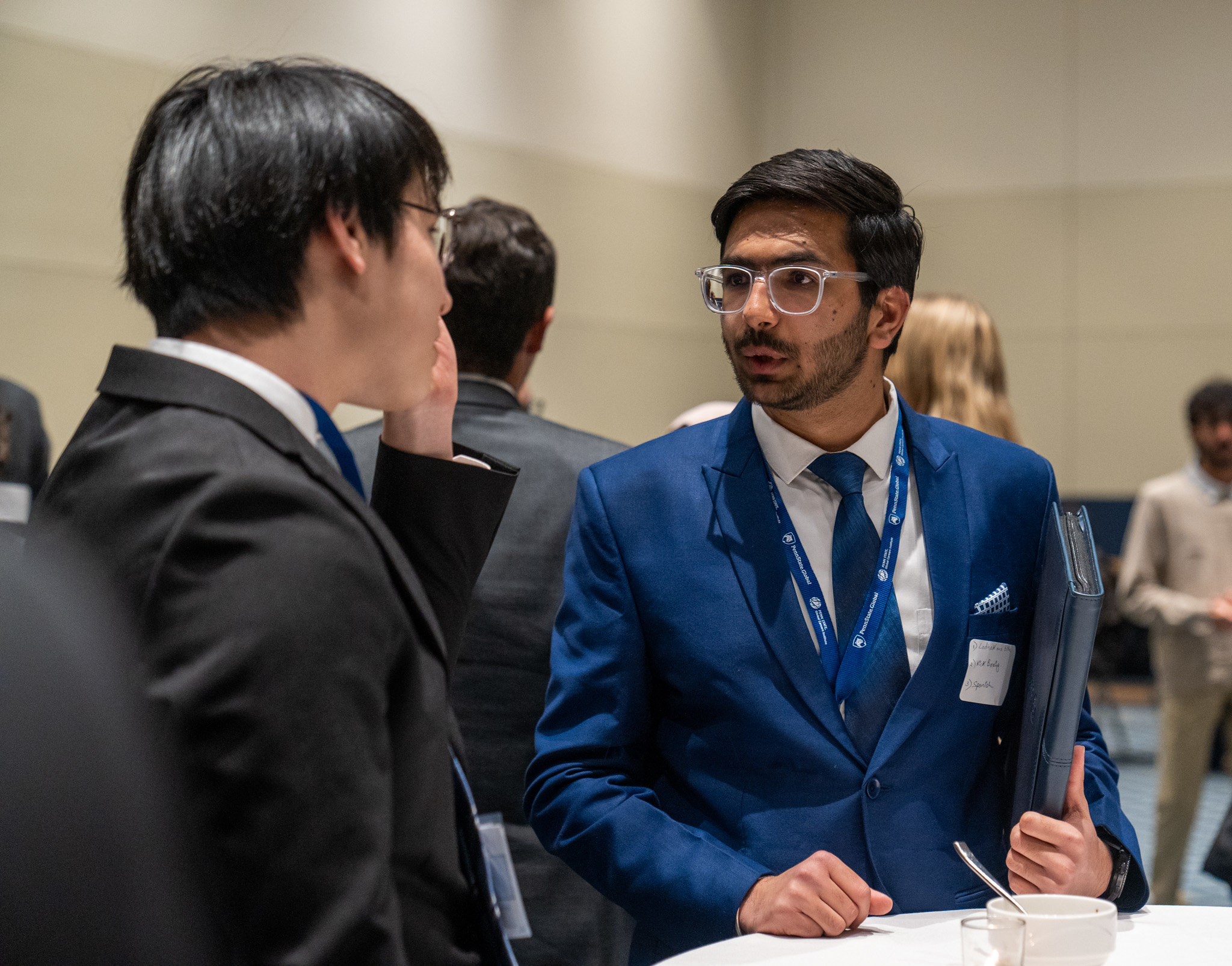 Two young men in suits talking to each other