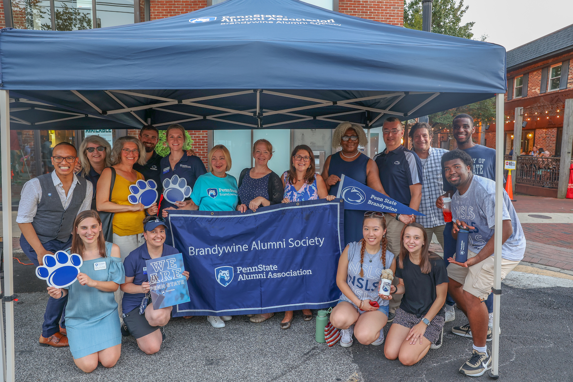 group of people at Dining Under the Stars holding Brandywine Alumni Society banner