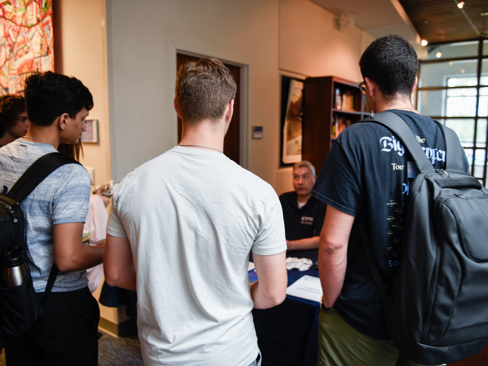 Three students with backpacks standing around a career counselor