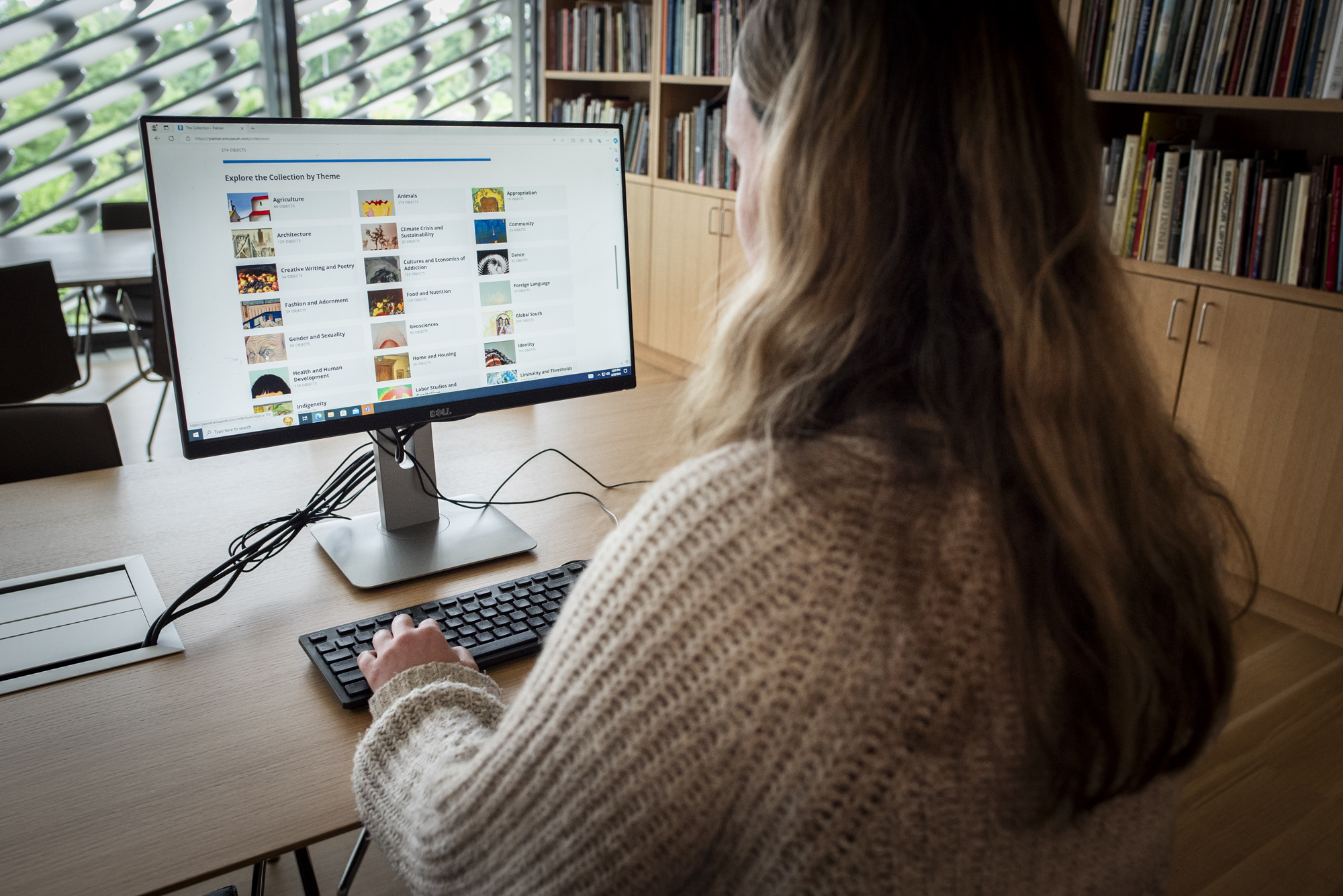 Woman in front of computer in library