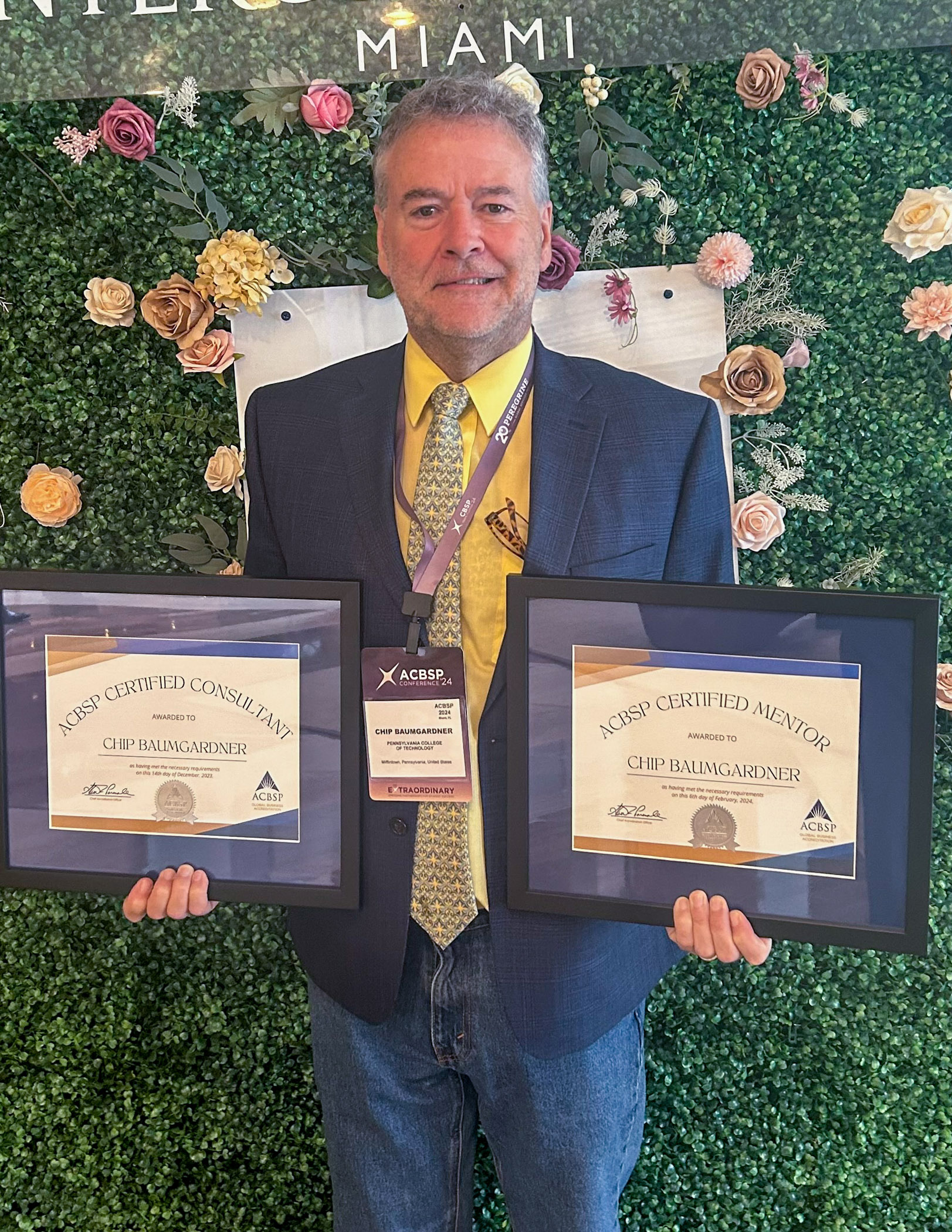 Chip D. Baumgardner holding two framed certificates