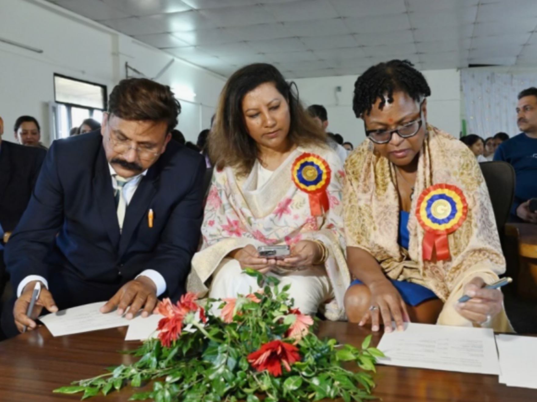 3 individuals look down at a document 