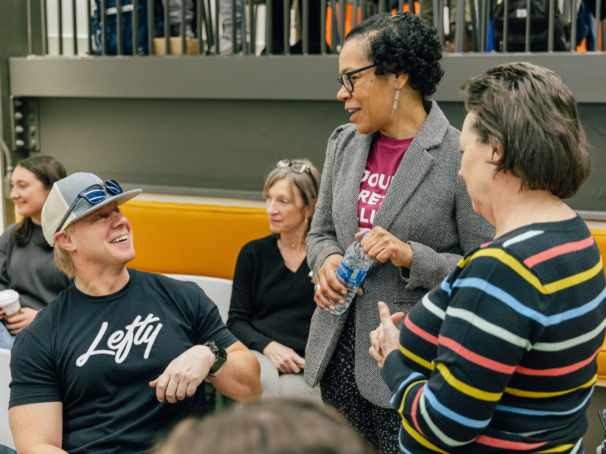 Three individuals engage in a conversation with one another