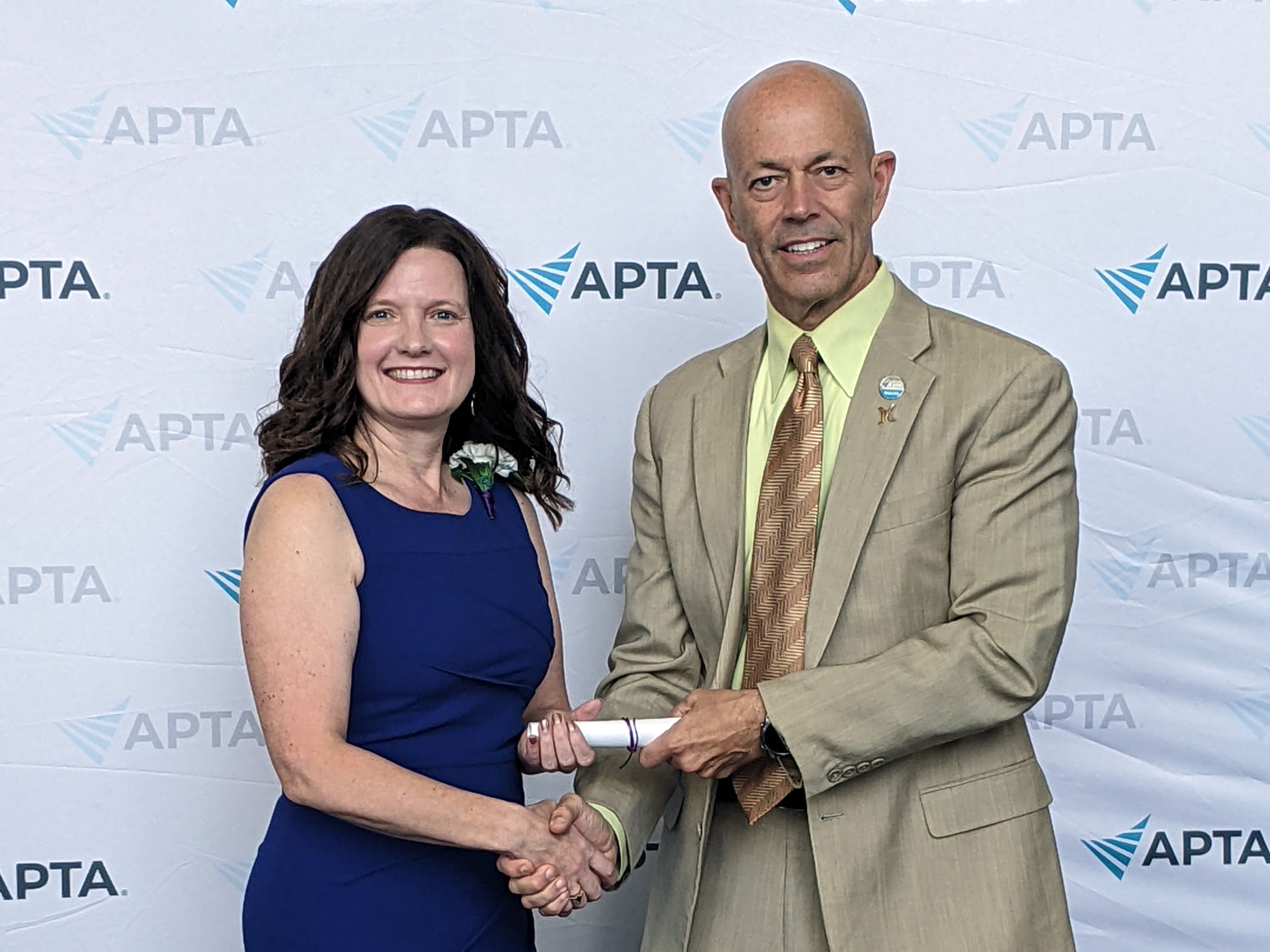 Pamela Pologruto standing beside Roger Herr, award in hand.