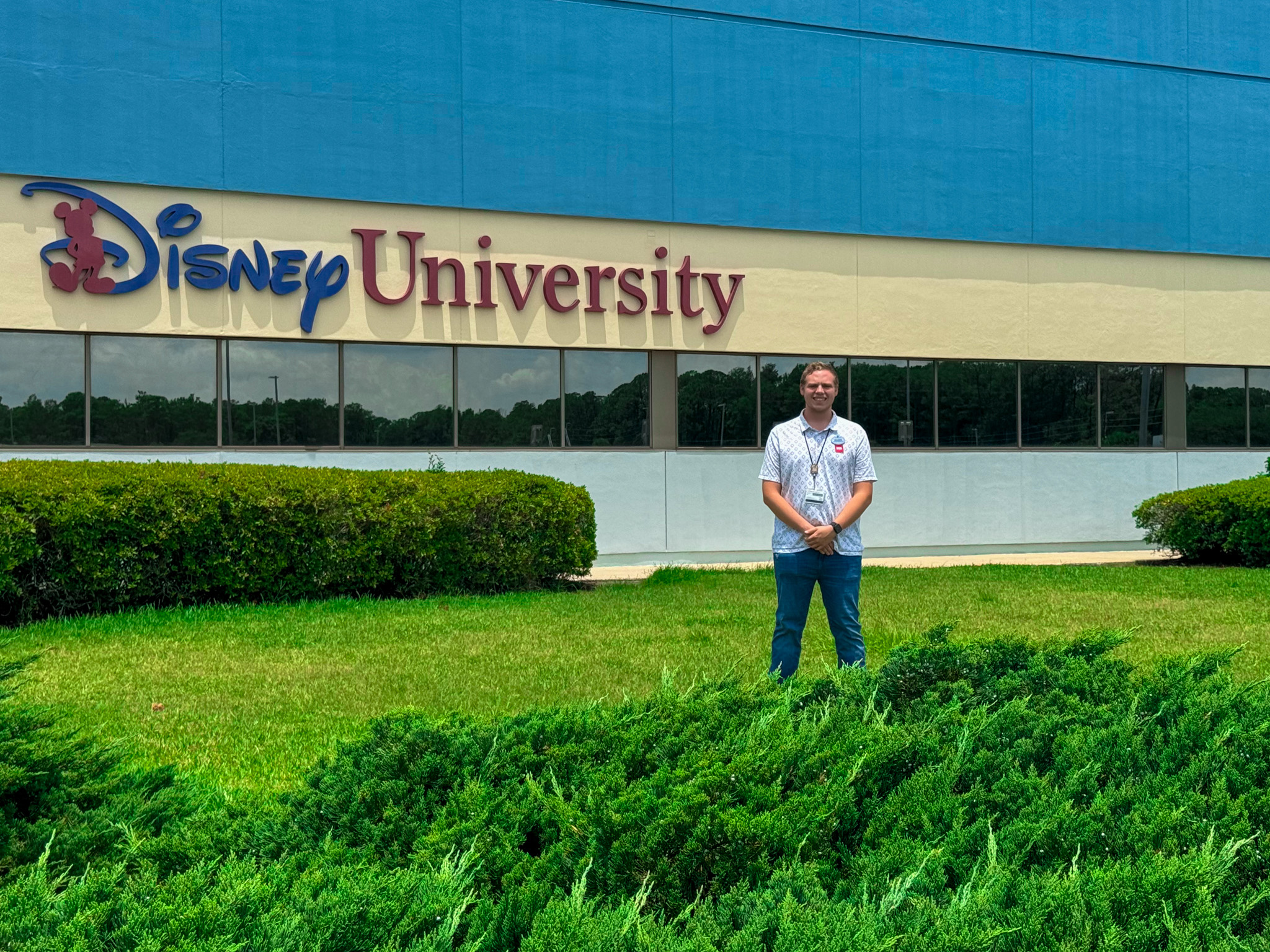 Rogers Myers stands outside Disney University on a bright, sunny day.