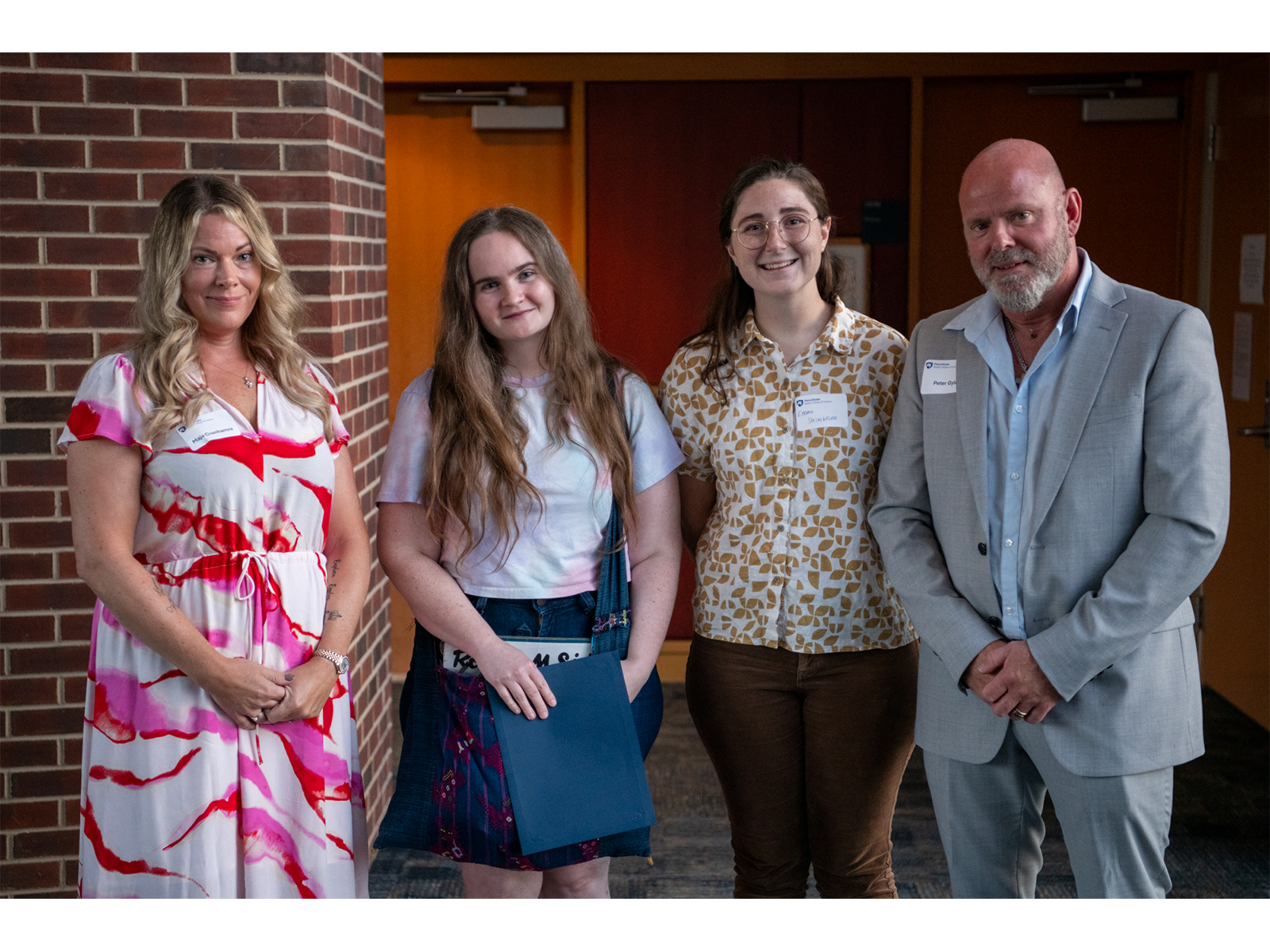 Be More Lovisa Graduate Student Scholarship recipients Šárka Blahnik (center left) and Emma Steinebronn (center right) stand with the parents of Lovisa Arnesson-Cronhamre, Maja Cronhamre (far left) and Peter Arnesson Gyld (far right).