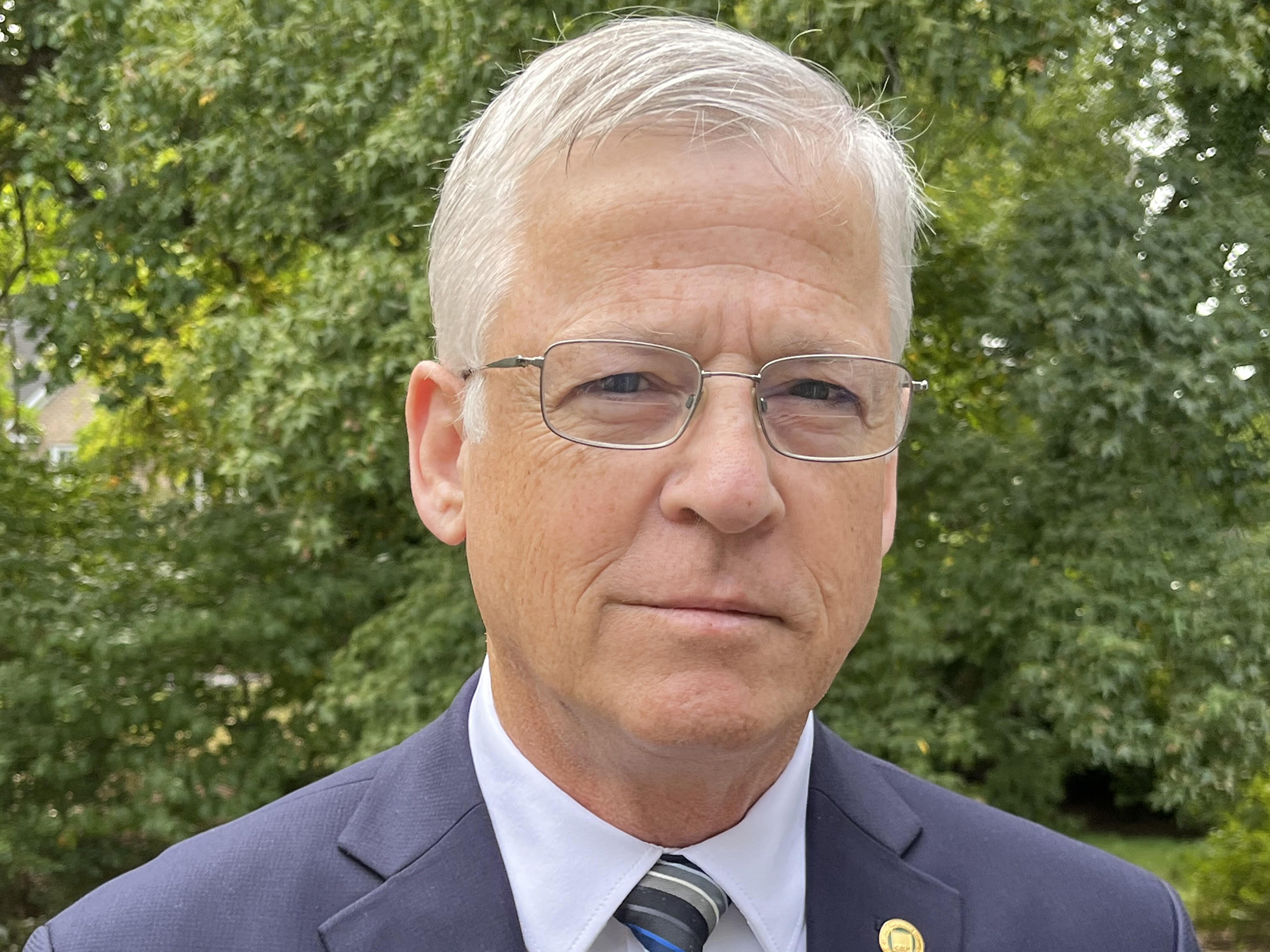 Bob Turner in a suit and tie standing outdoors