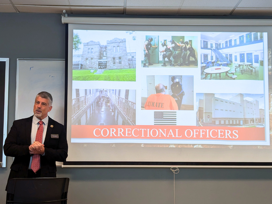 a corrections director speaks to a class of students in front of a powerpoint