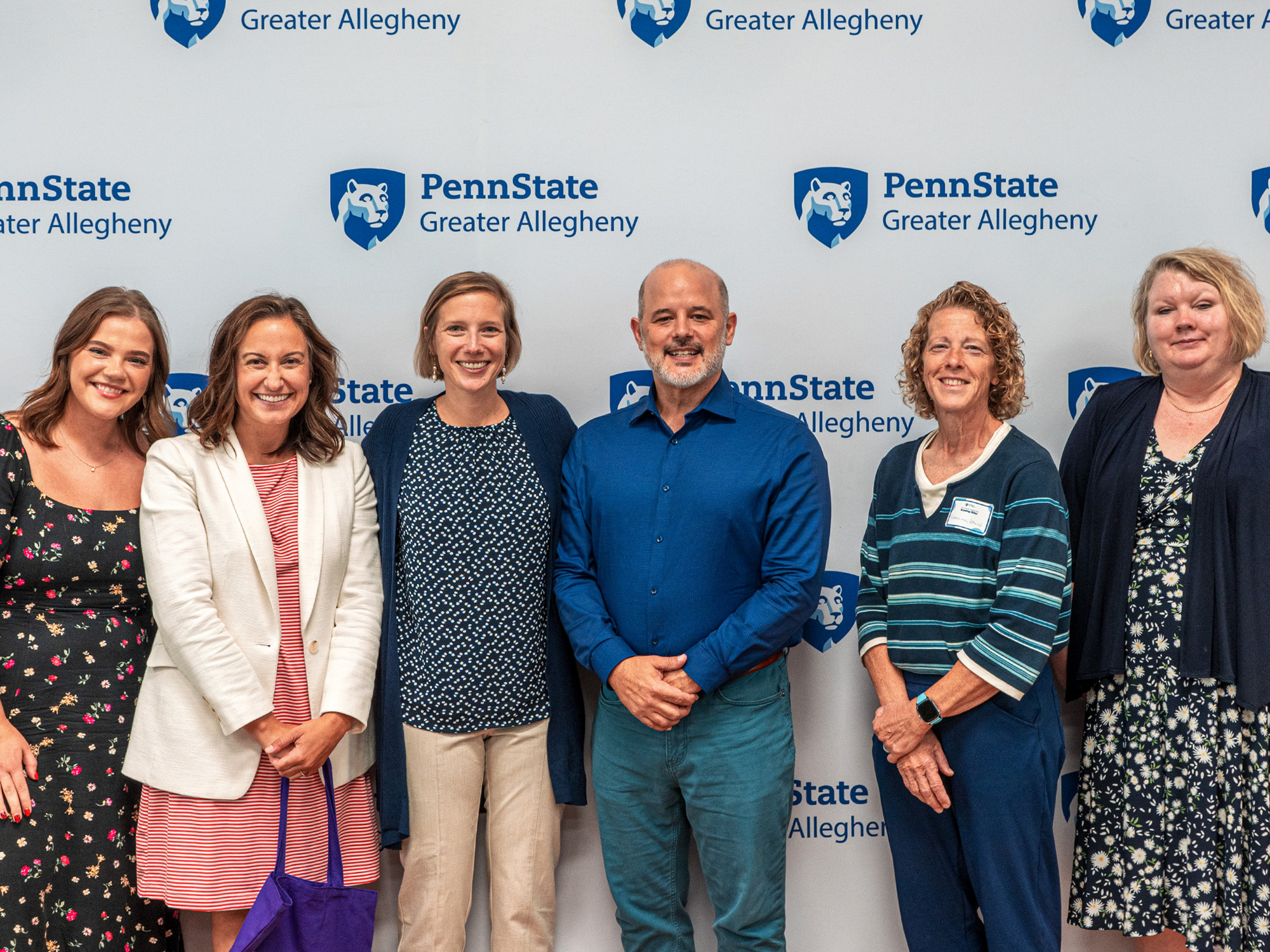 Group photo in front of a Penn State Greater Allegheny backdrop