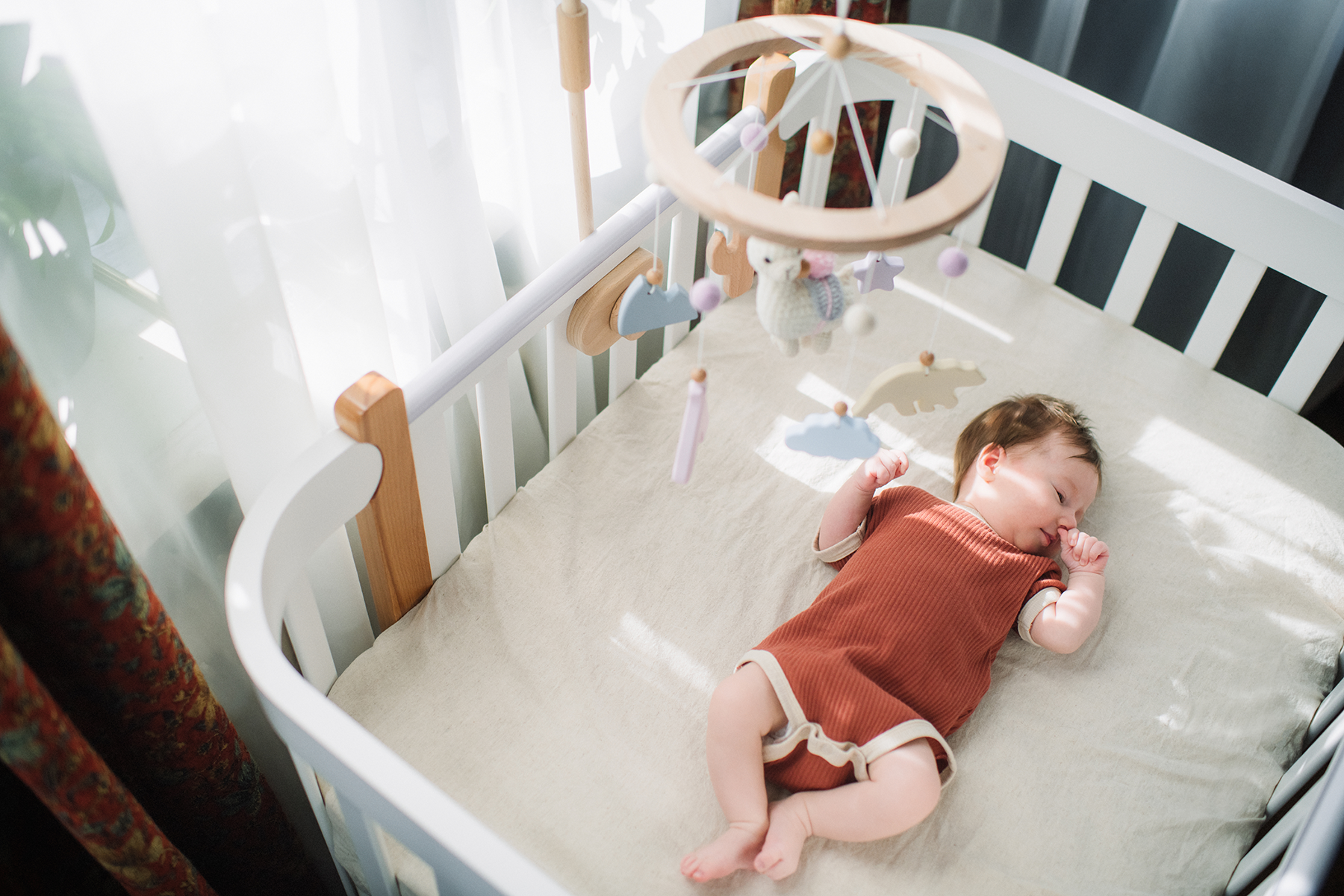 baby sleeping on back in a crib