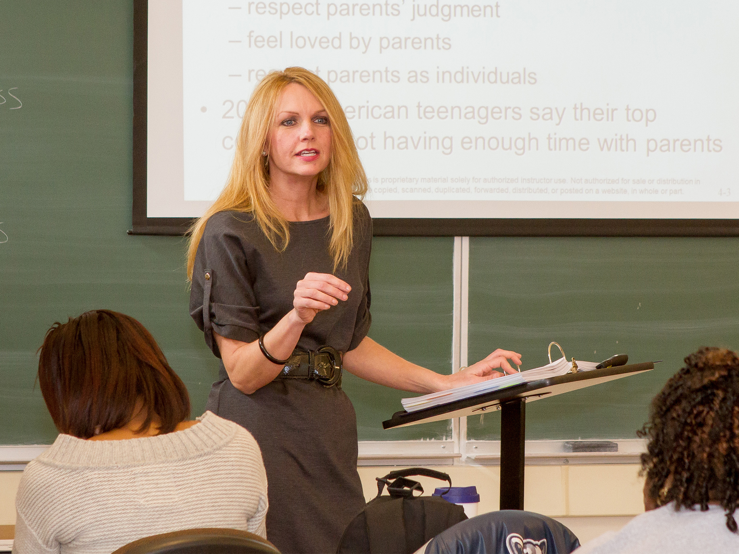 Roxanne Atterholt standing at a podium lecturing to students in a classroom