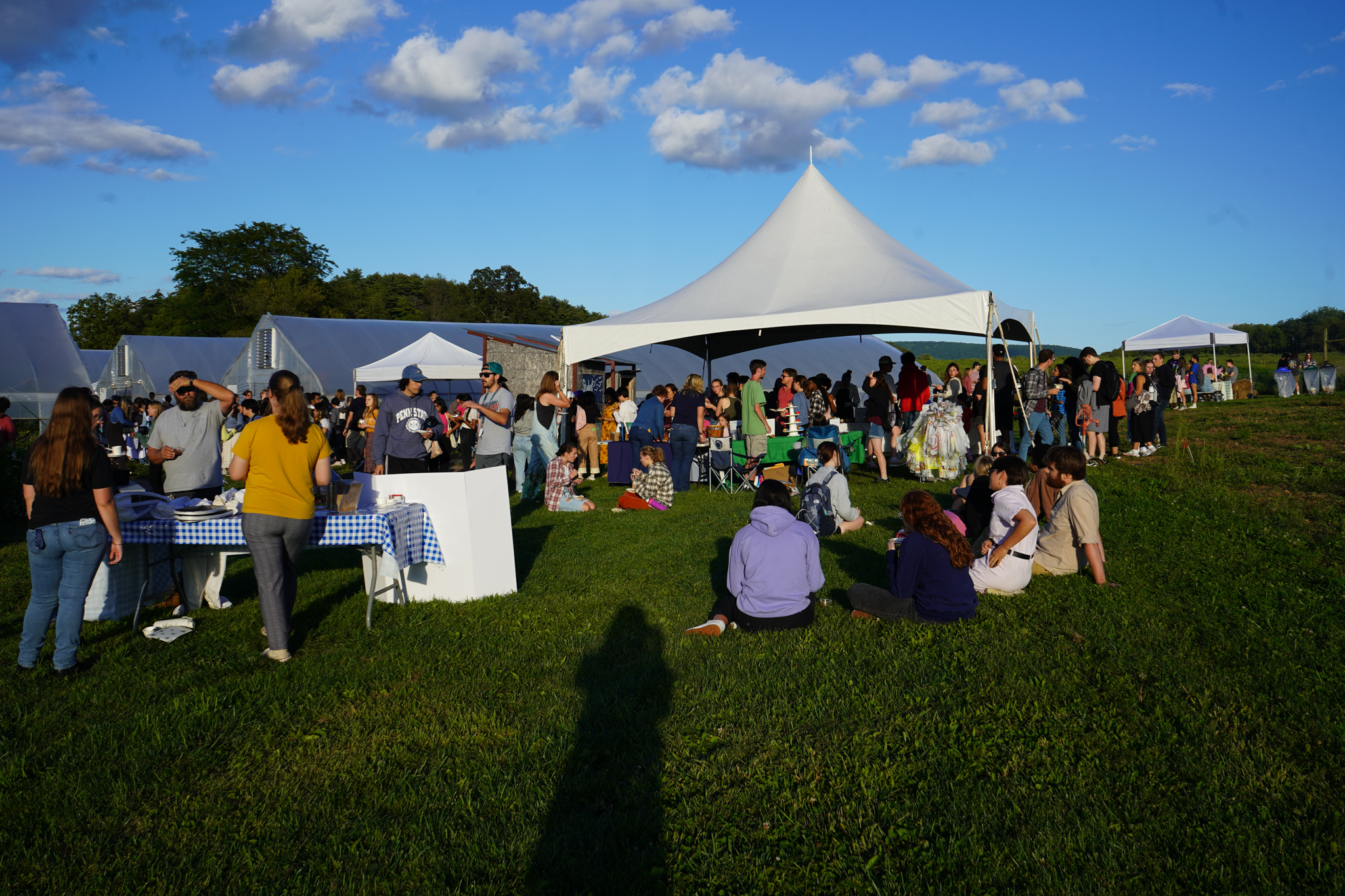 Guests gather in the grass and around displays at the Student Farm Harvest Fest