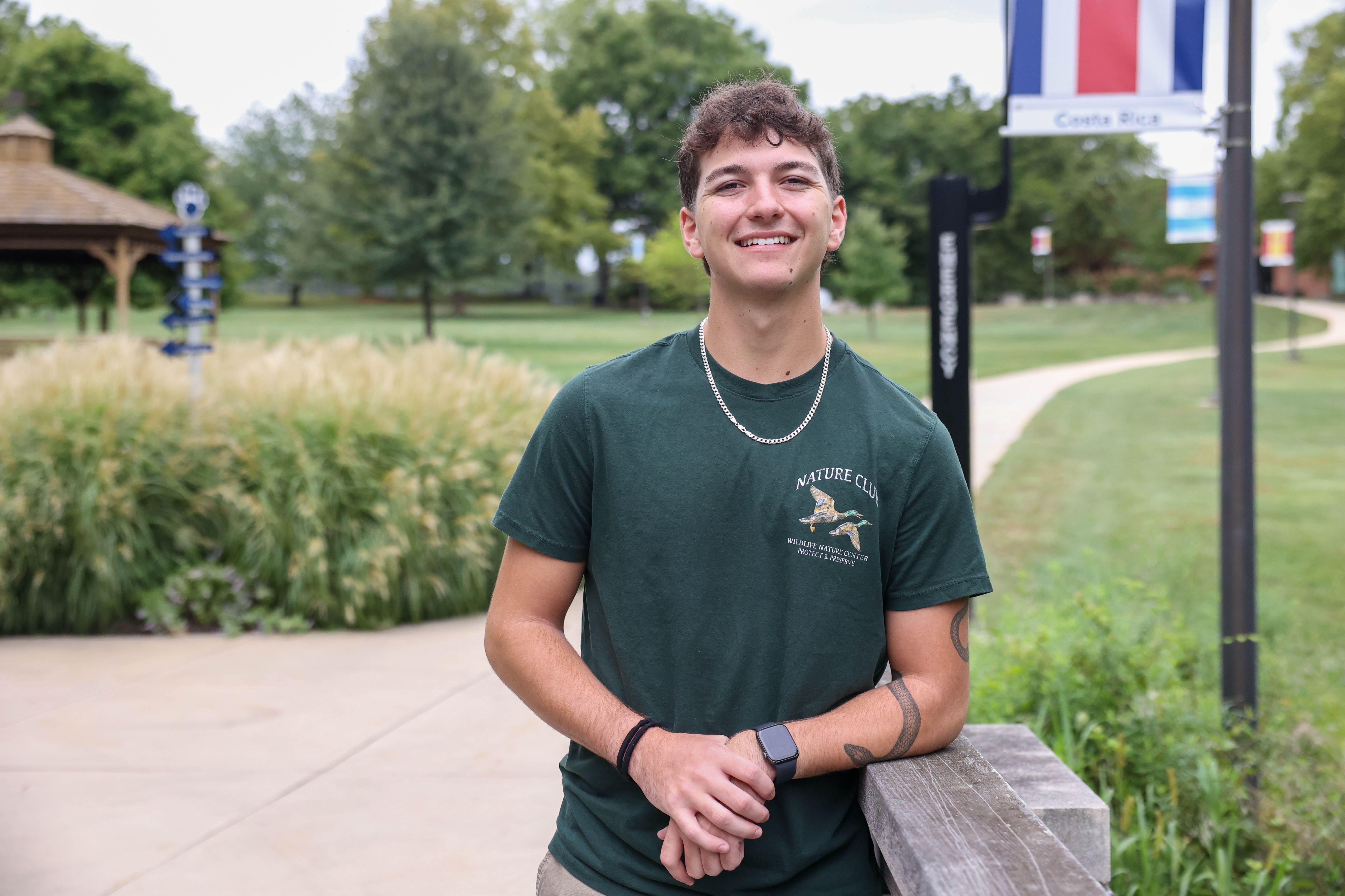 A male student stands on a sidewalk at Penn State Brandywine.