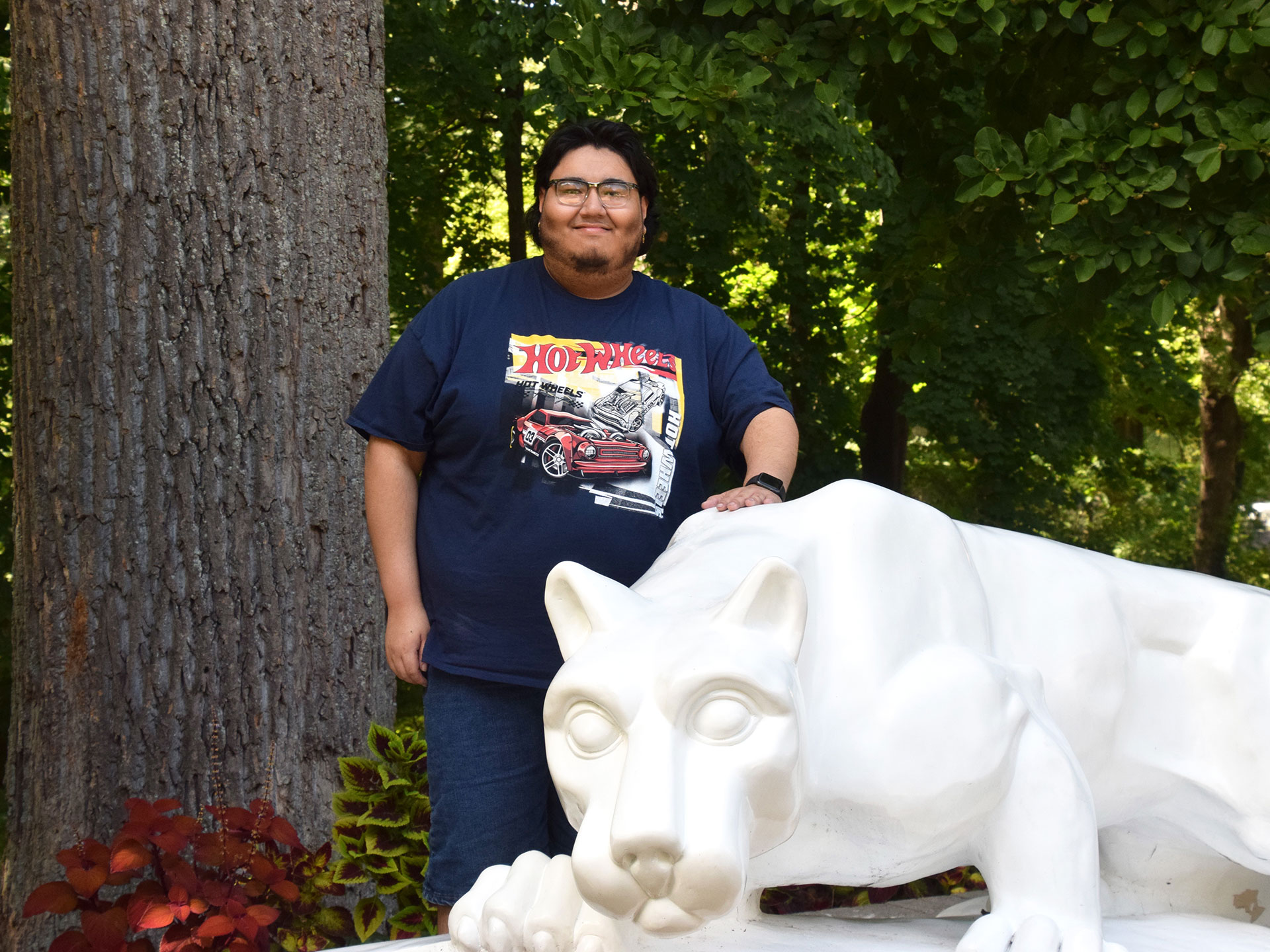 Man standing behind lion statue