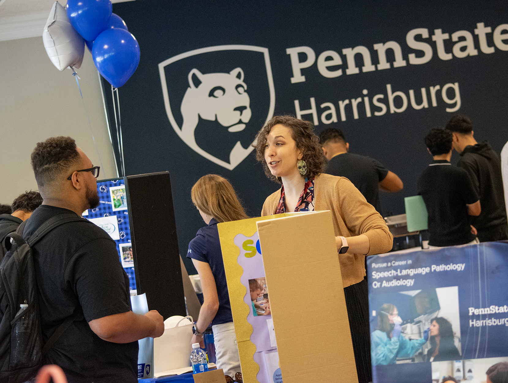 A student talks with a faculty member at a table during Majors Fest