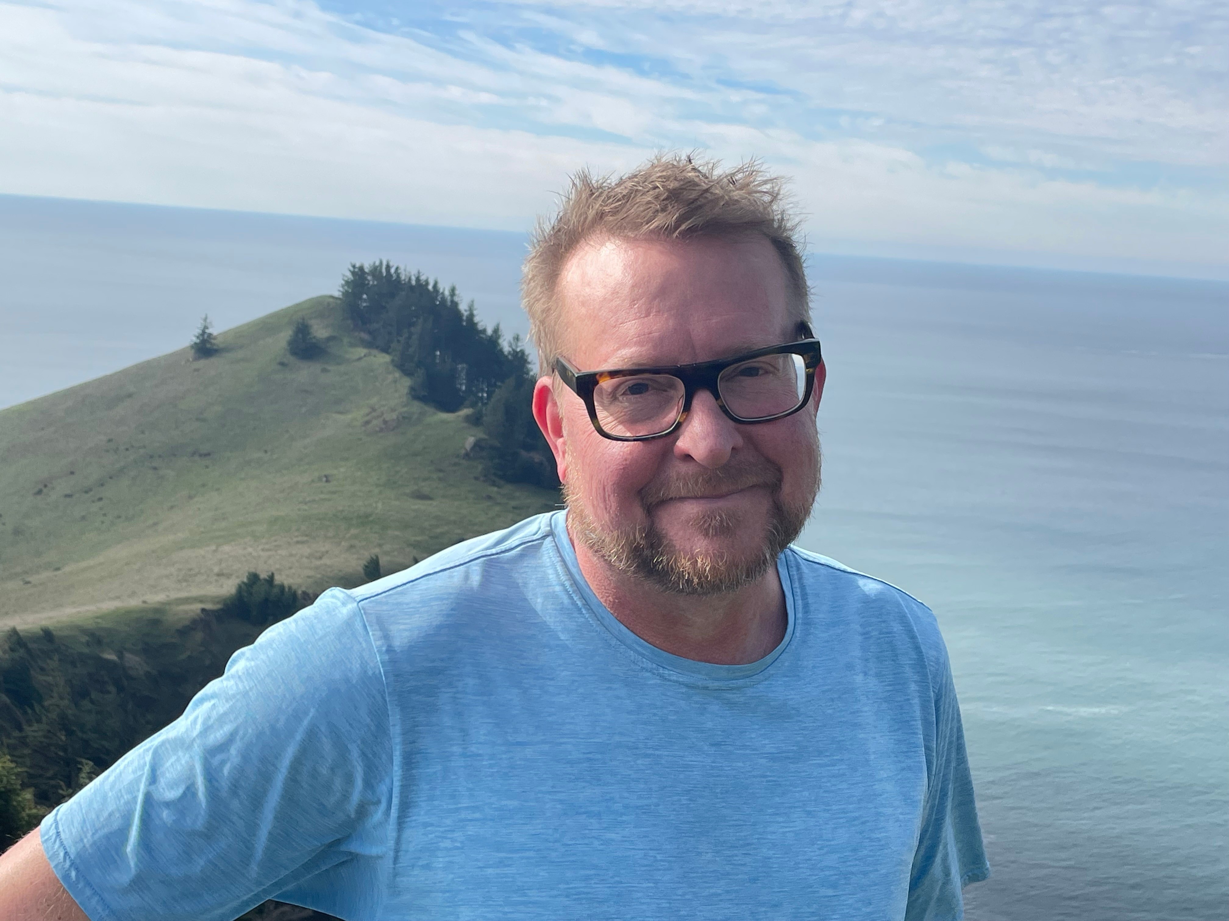 Person standing in front of ocean backdrop 