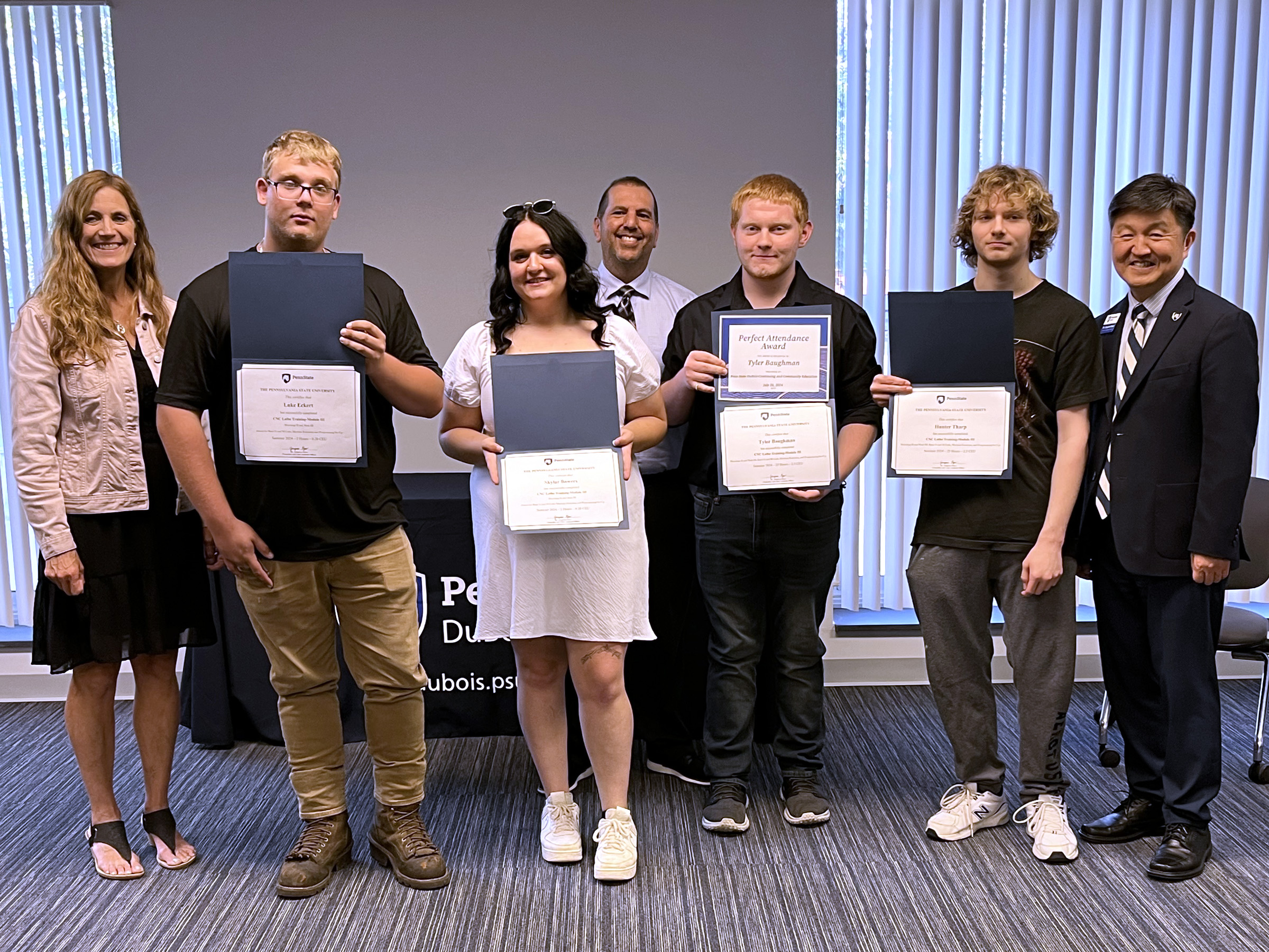 Students and staff members gather for a group photo during the graduation ceremony for the post high school CNC program at Penn State DuBois. From left to right, Pam Streich, executive director of  Workforce Solutions of North Central Pennsylvania, Luke Eckert, Skylar Bowers, John Brennan, director of continuing and community education at Penn State DuBois, Tyler Baughman, Hunter Tharp, Jungwoo Ryoo, chancellor and chief academic officer at Penn State DuBois.