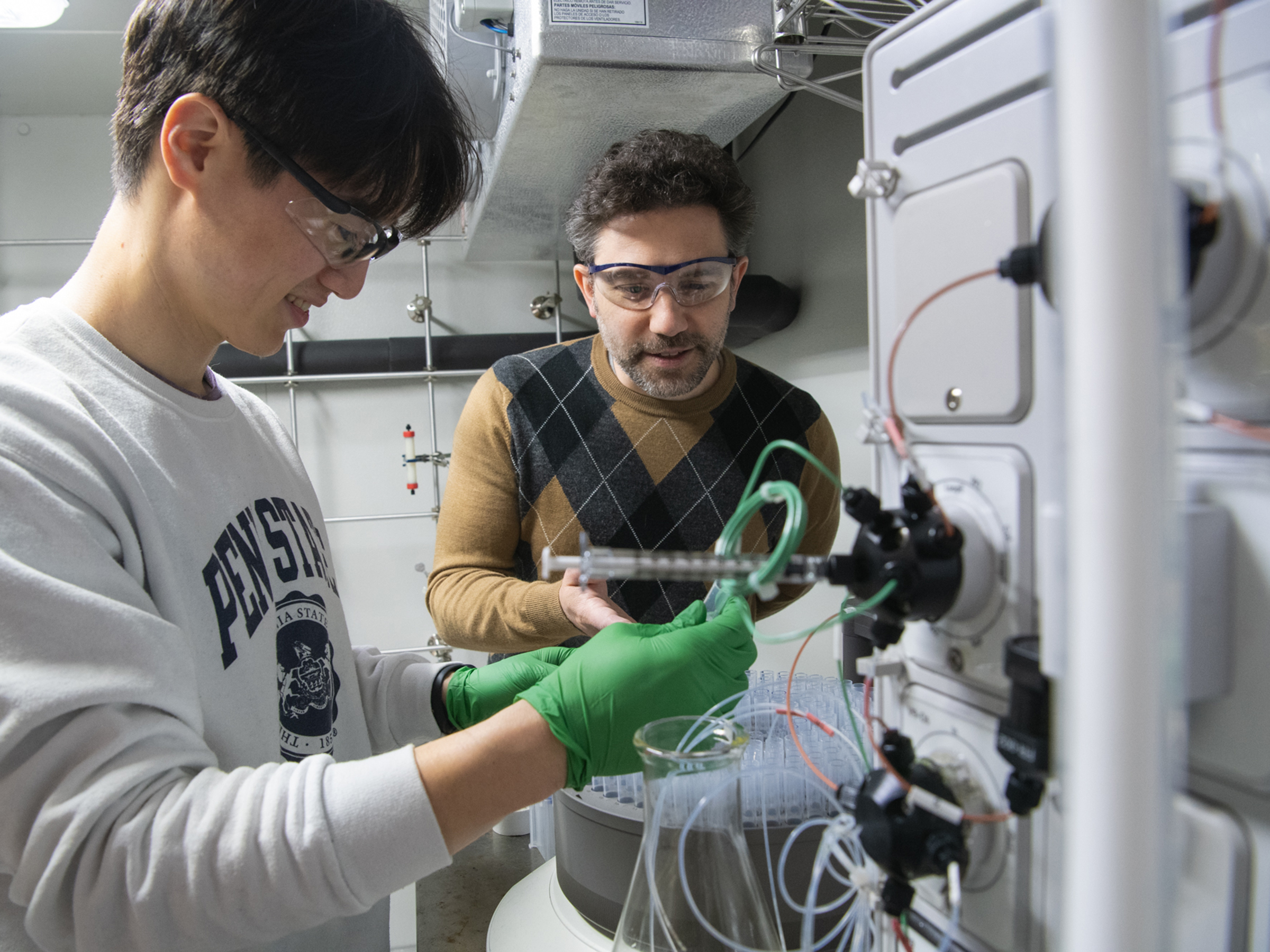 Two researchers working on an instrument in a chemistry lab