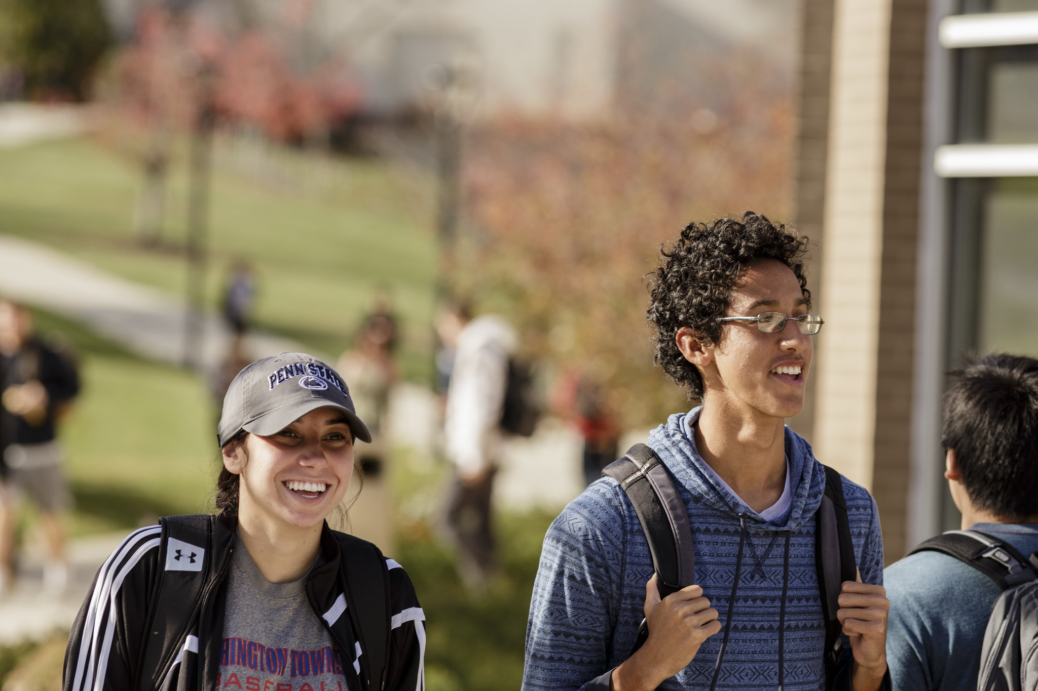 Two smiling students walk across Penn State Berks campus