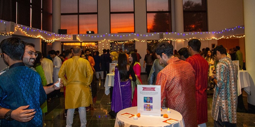 People gather at an event wearing Indian attire